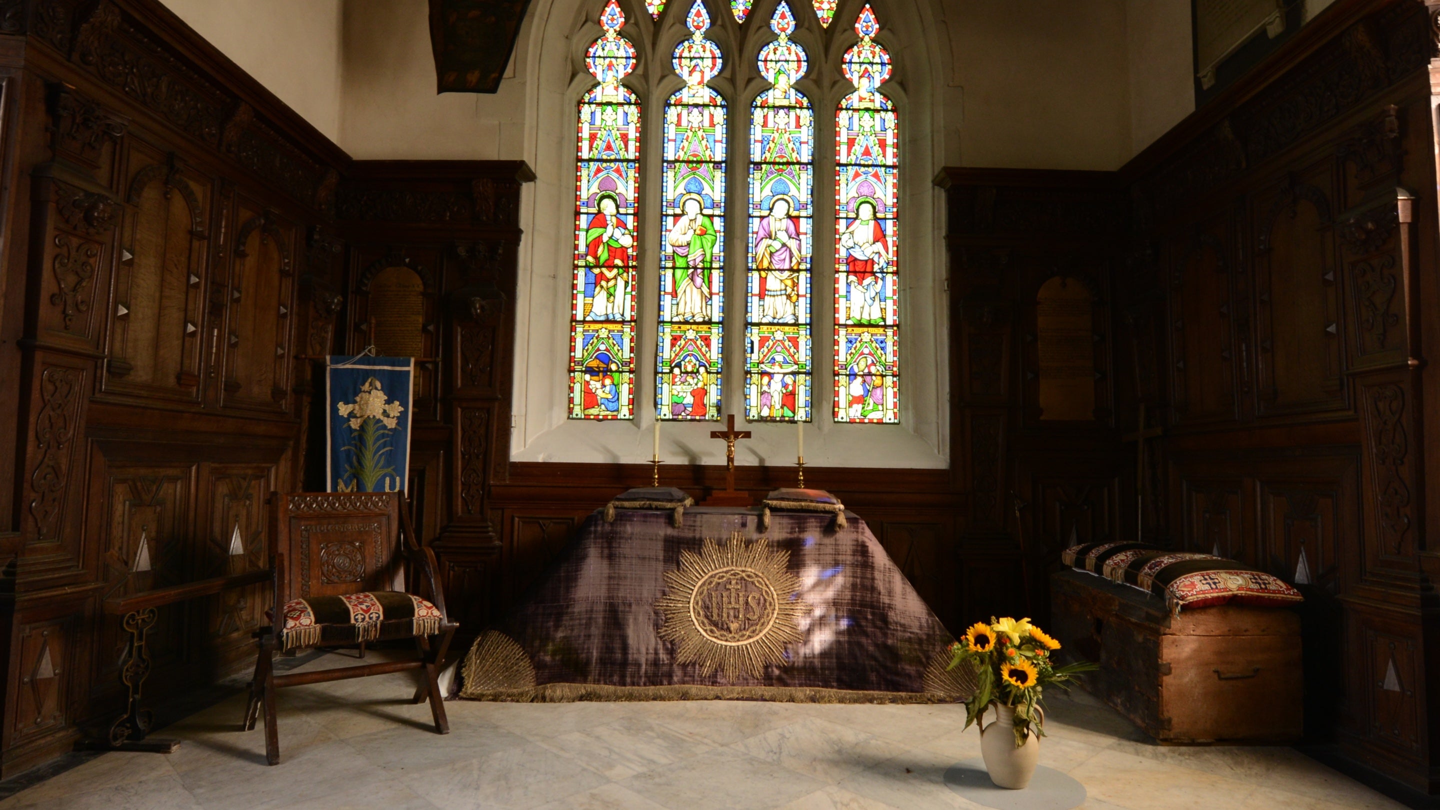 Images shows the altar at Staunton Harold Church in front of a stained glass window.