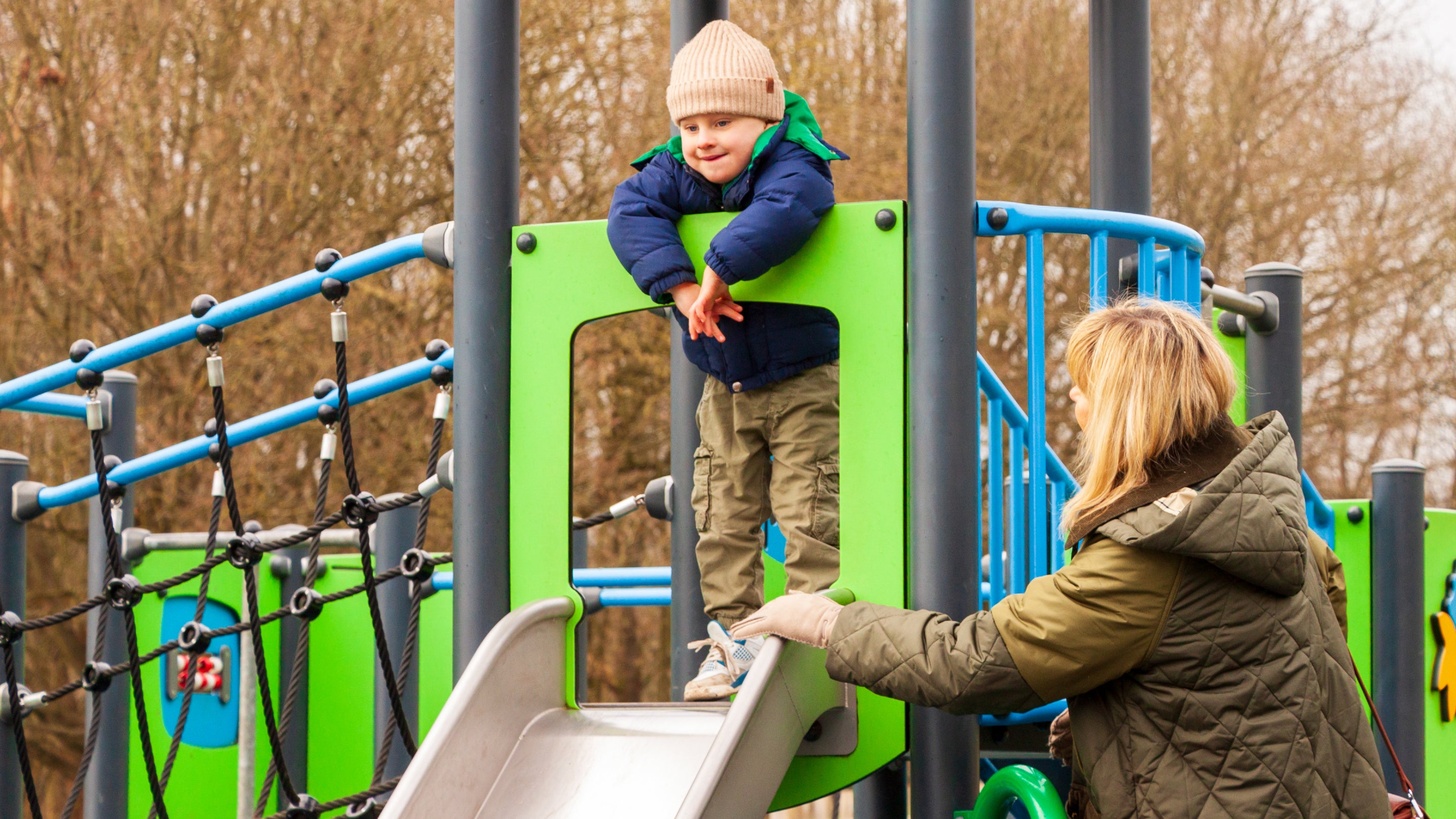 A young boy playing on a slide in the playground at Staunton Harold