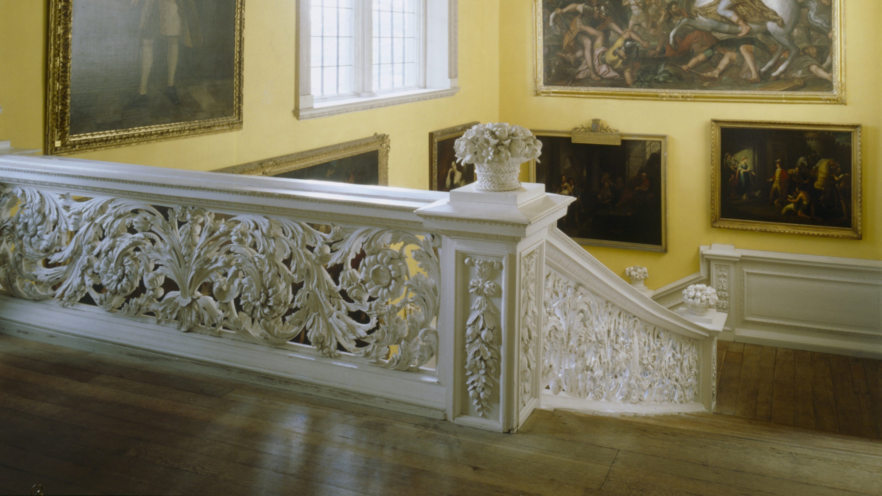 View from the top landing of the Great Staircase, showing the elaborate carved balustrade by Edward Pierce 1676-7 plasterwork ceiling by James Pettifer & wall & ceiling painting.