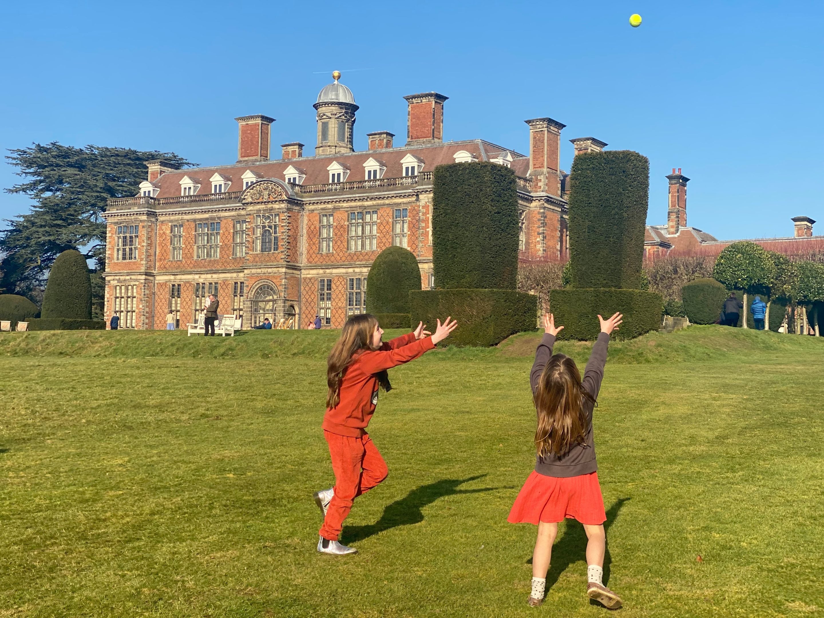 Two children playing in the Gardens with Sudbury Hall in the background