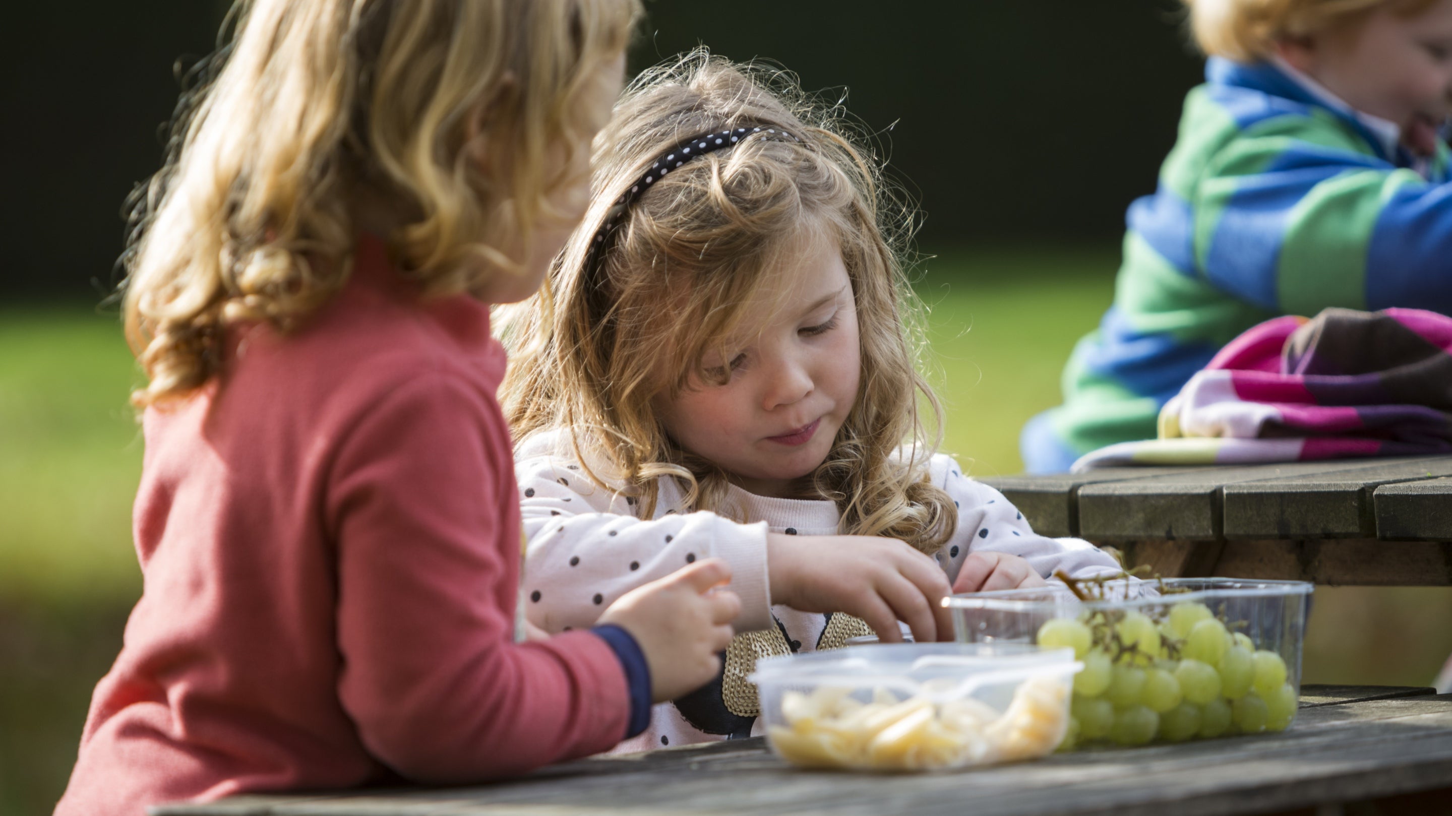 A family eating at the picnic tables at Sudbury Hall, Derbyshire.