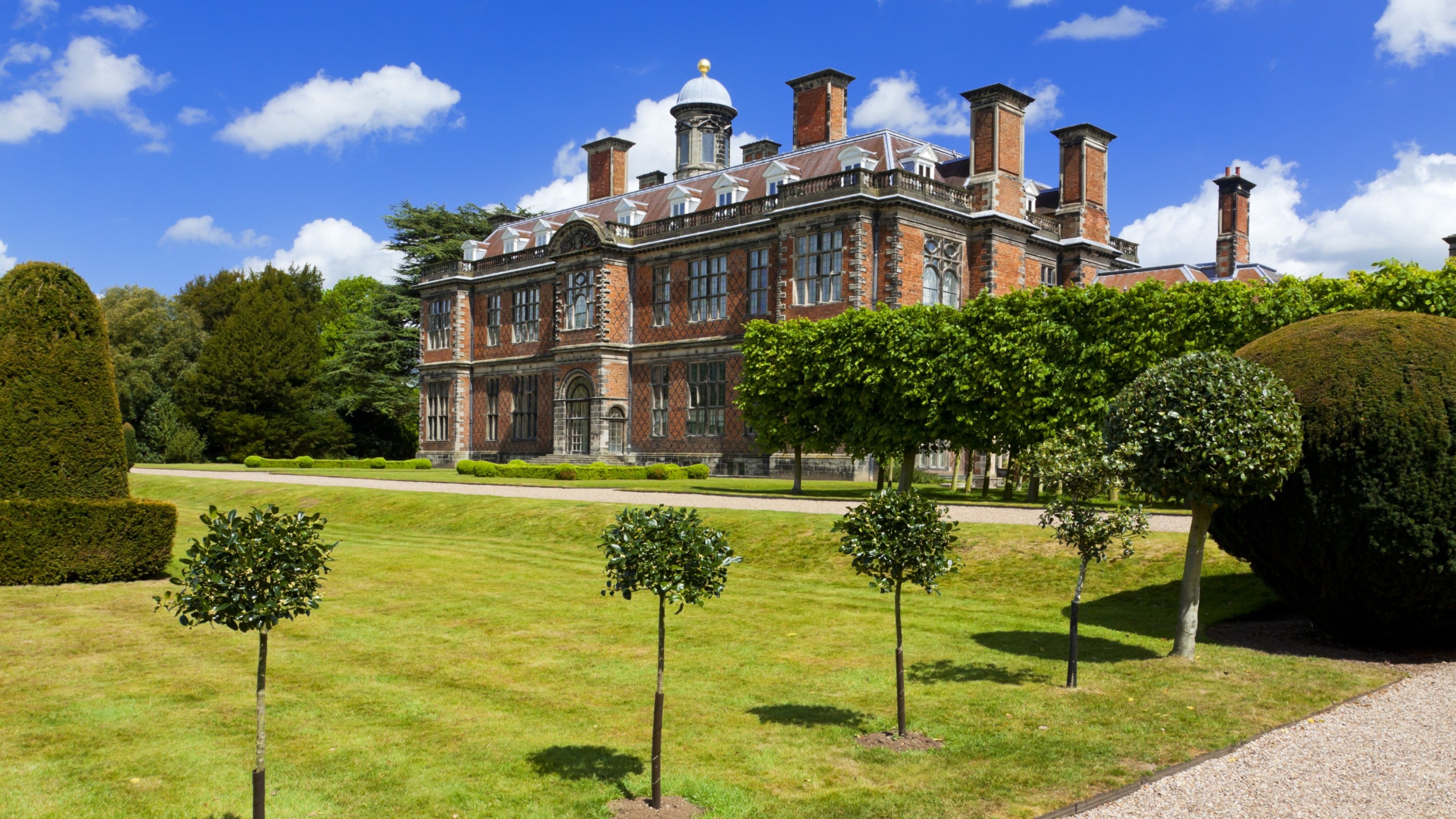 The south front of The Children’s Country House at Sudbury, Derbyshire, with topiary trees in the foreground