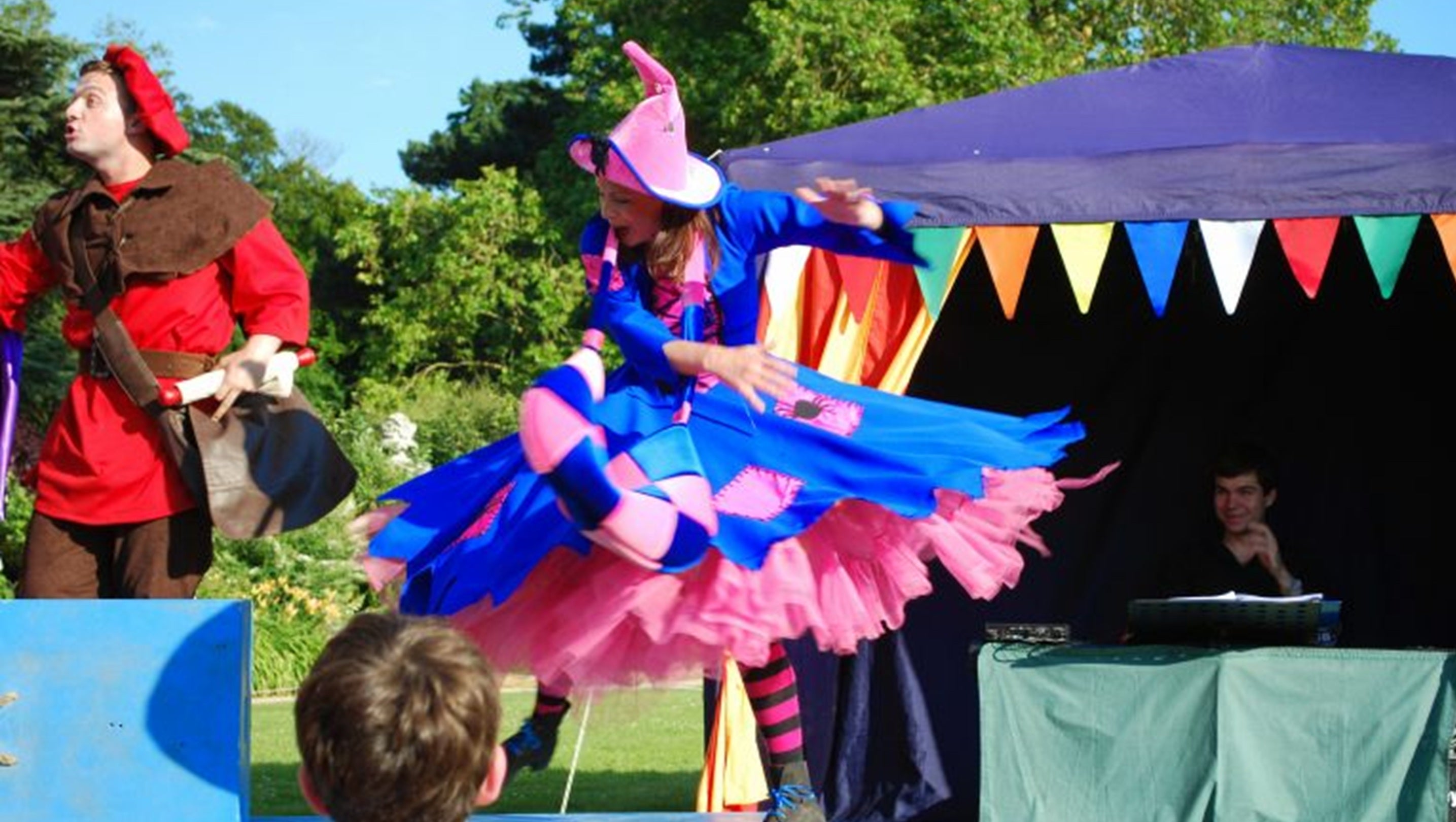 Actors in colourful costumes perform outside