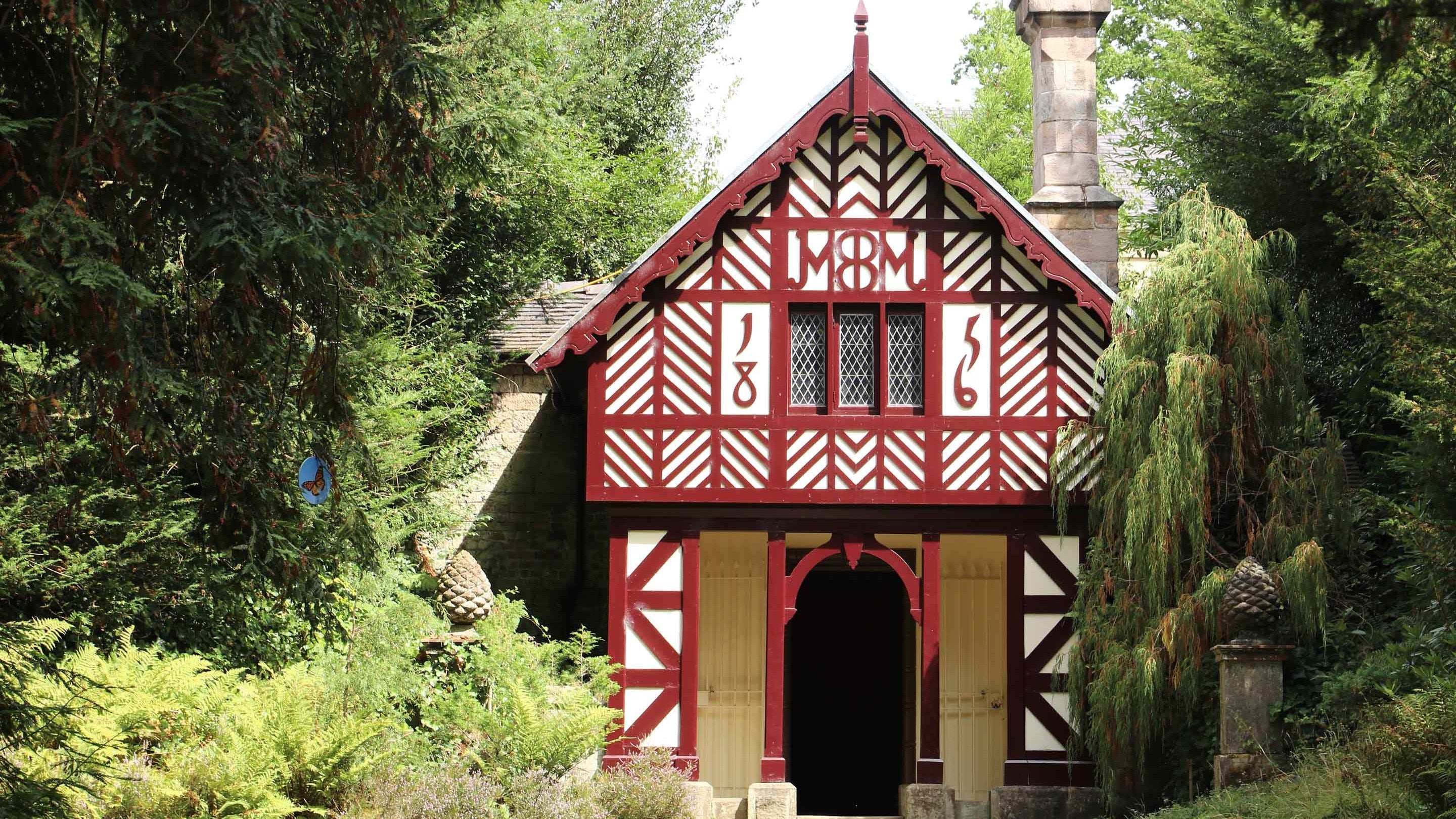 The red and white half-timbered Cheshire Cottage, with the date 1856, in Biddulph Grange Garden, Staffordshire
