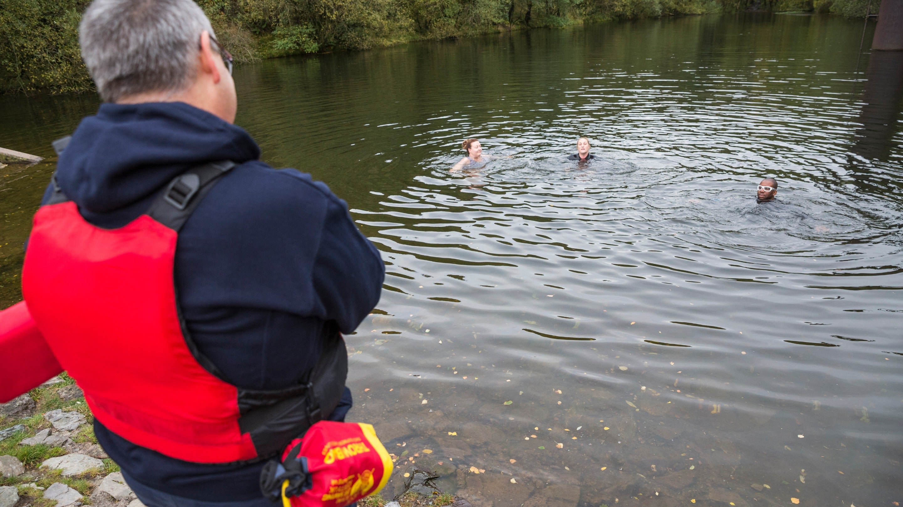 Visitors wild swimming at Carding Mill Valley, Shropshire