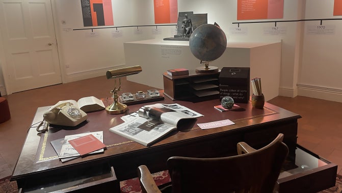 View of an art gallery from behind an old wooden desk.