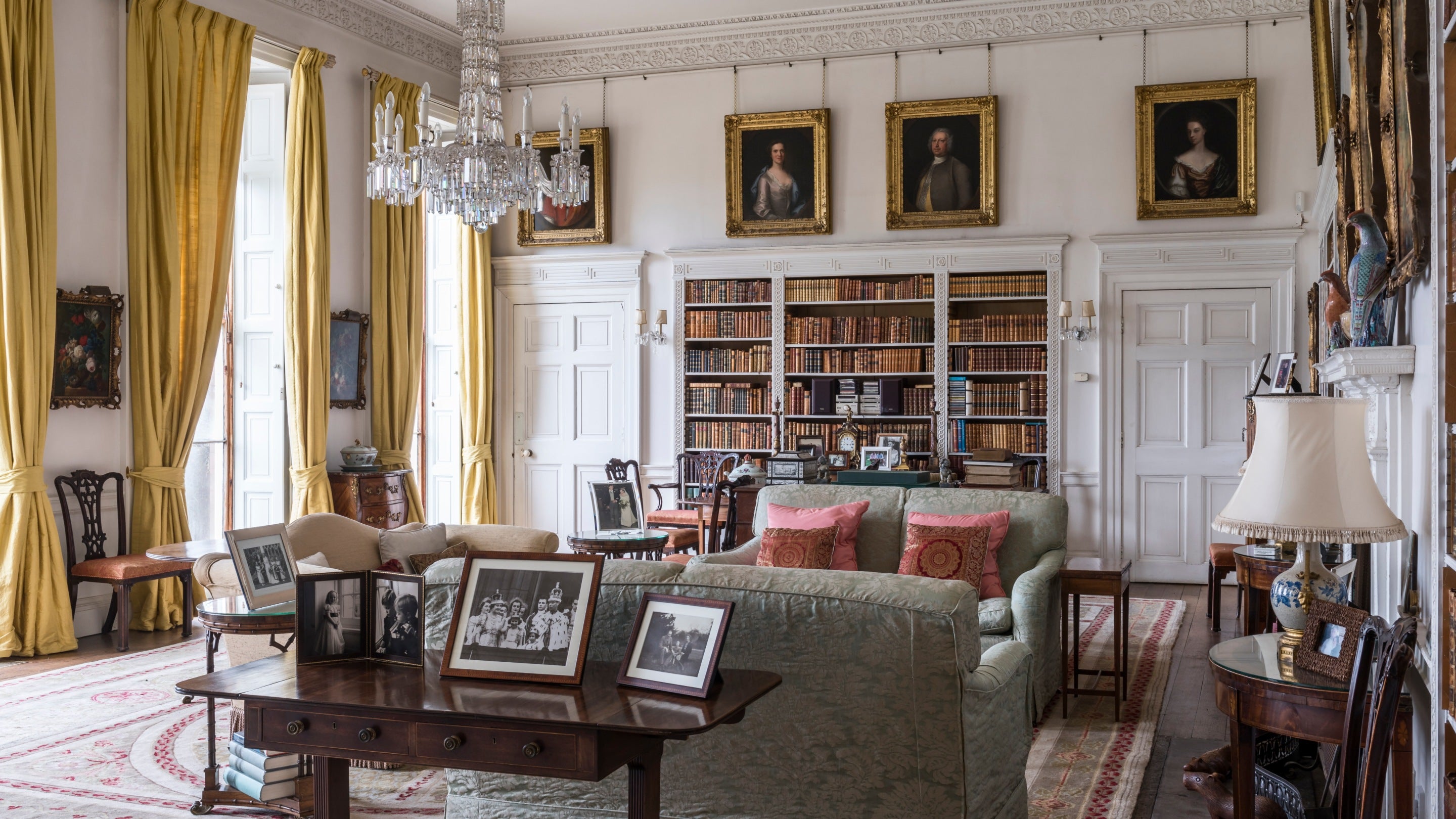 The interior of the Library at Dudmaston House, Shropshire, with shelves built into the walls for books and sofas arranged in the centre of the room.