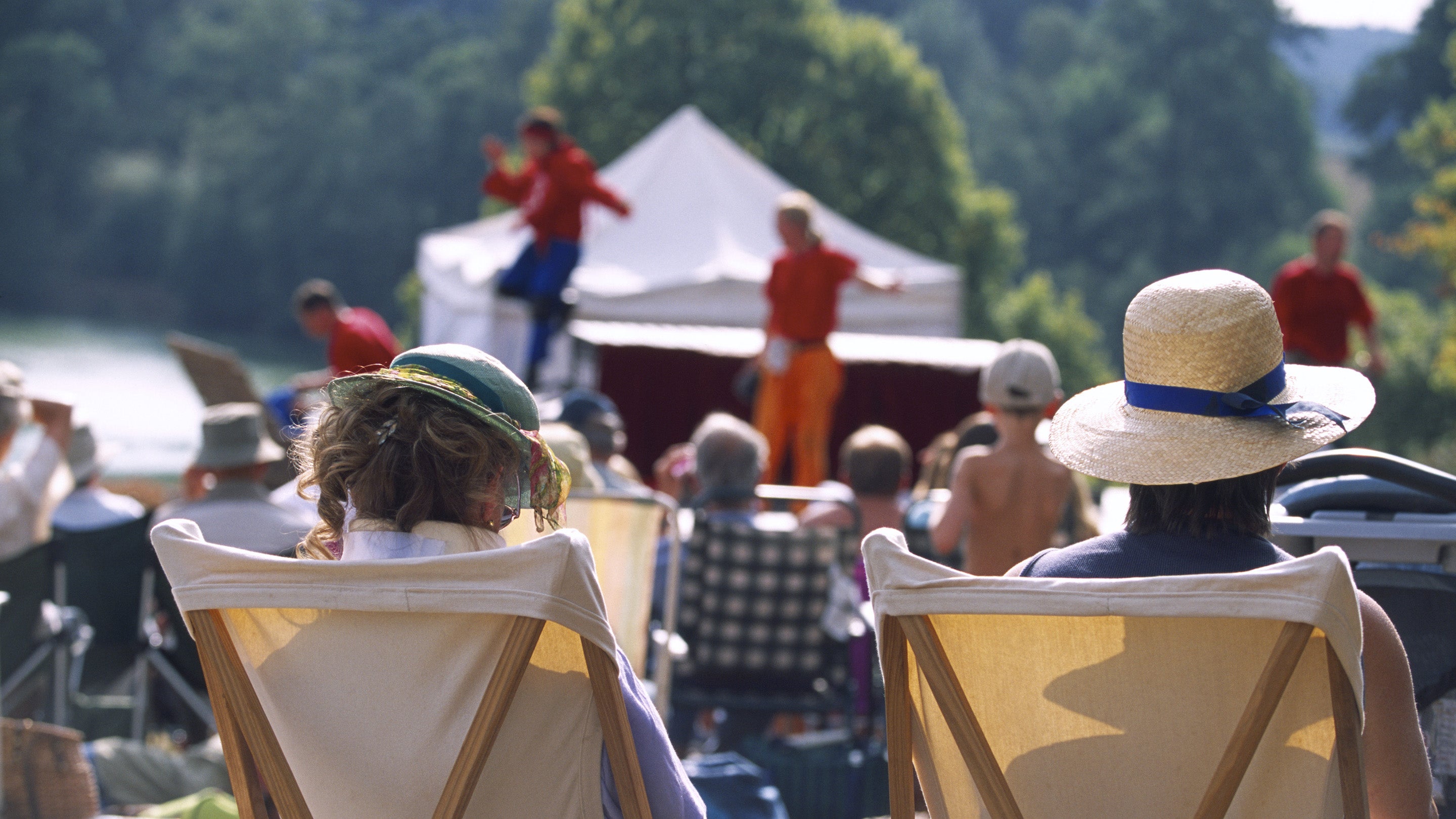 View from behind two visitors seated in deckchairs as part of the audience at the Illyria Theatre Company's production of Ali Baba & the Forty Thieves at Dudmaston, Shropshire