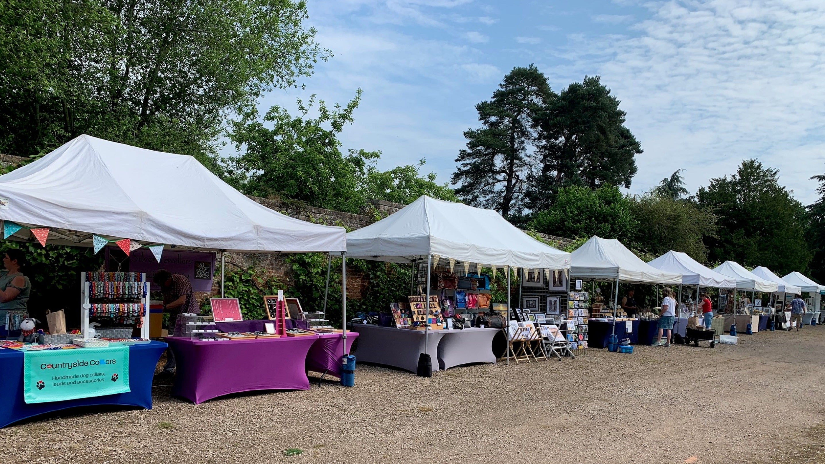A row of stalls are set out on a sunny day.