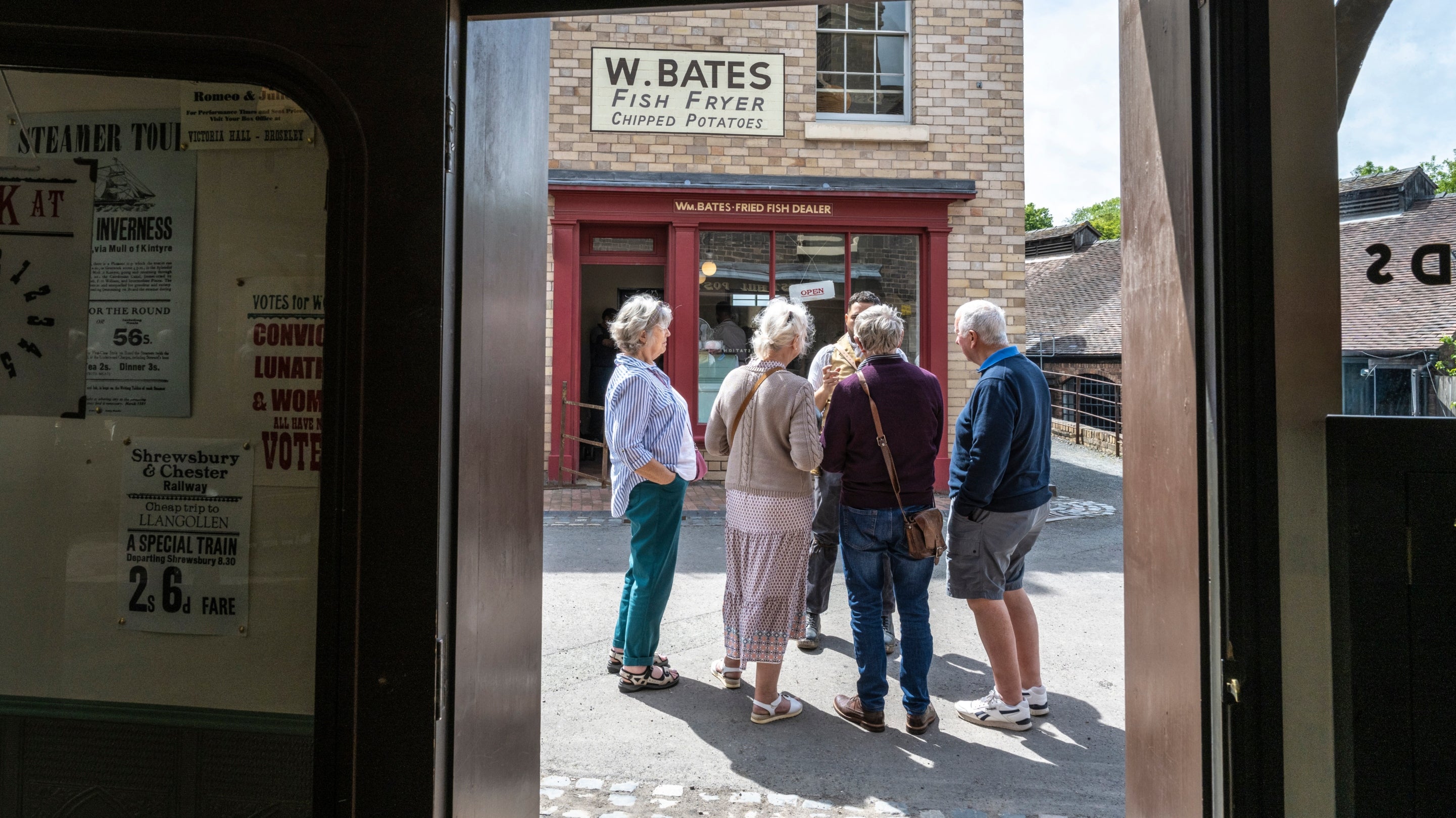 Visitors chatting with a guide at Blists Hill Victorian Town, Ironbridge Gorge, Shropshire