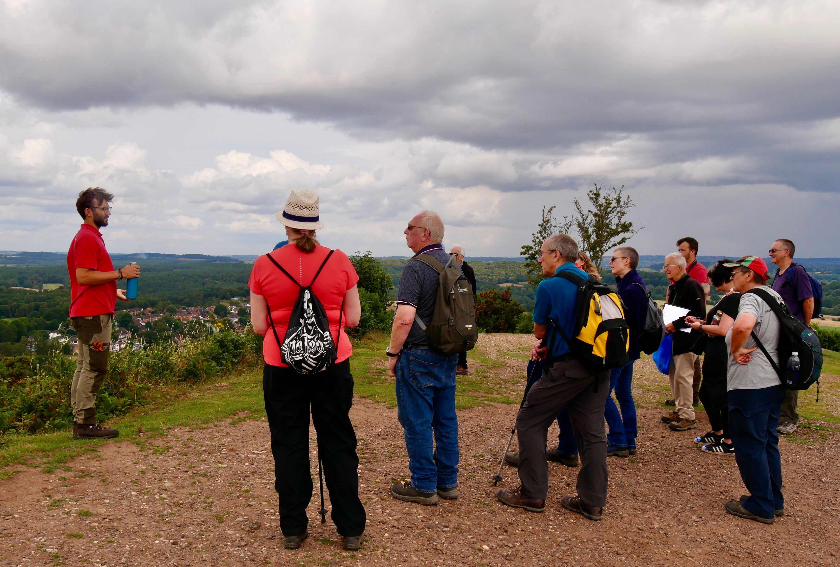 Ranger talking to walkers with view over Kinver
