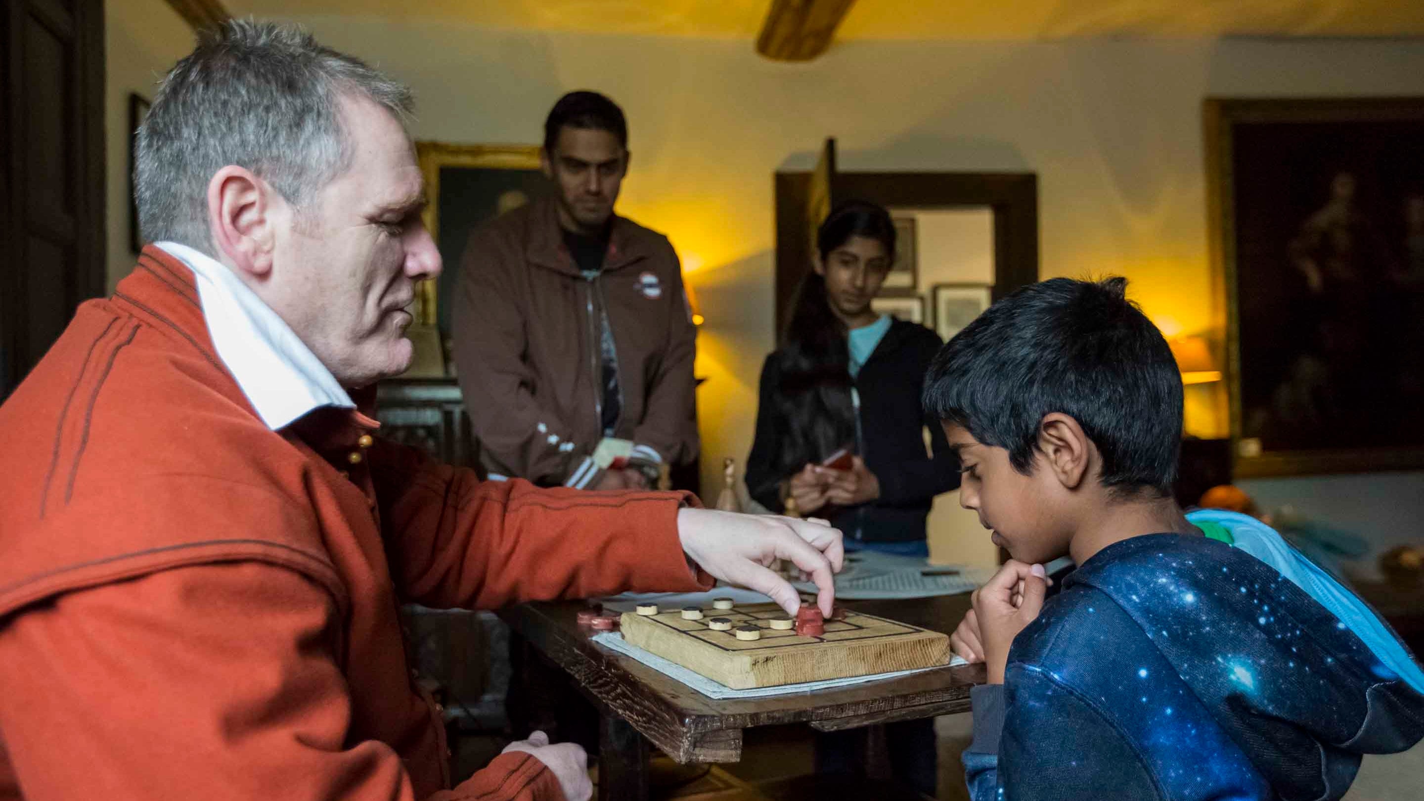 A costumed interpreter with visitors in the Parlour at Moseley Old Hall, Staffordshire.