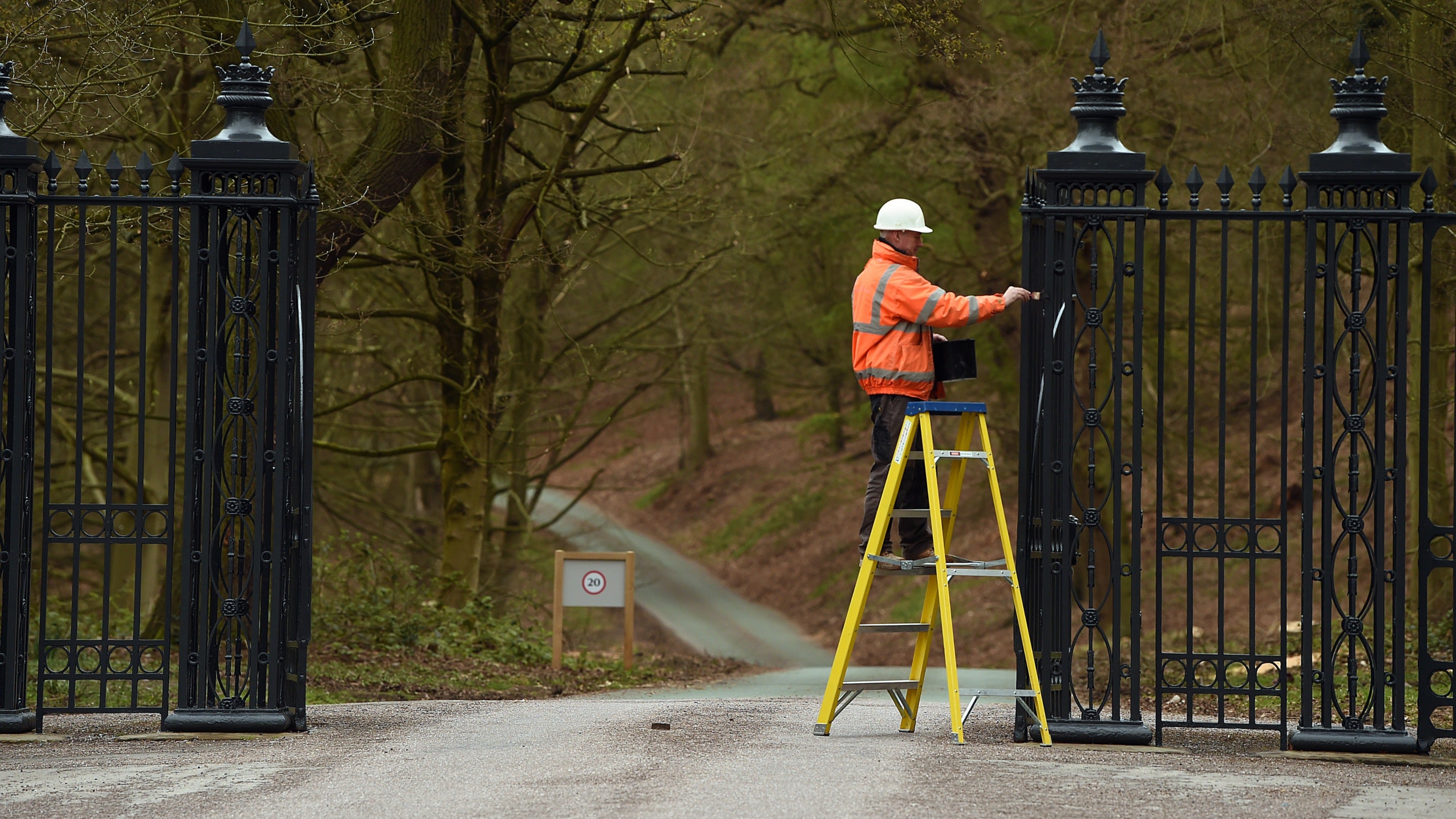Estate worker painting the iron gates at Shugborough Estate, Staffordshire