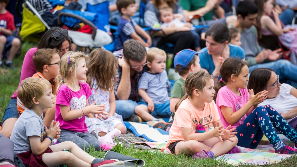 Audience members enjoying an open-air theatre performance in the garden at Shugborough Estate, Staffordshire