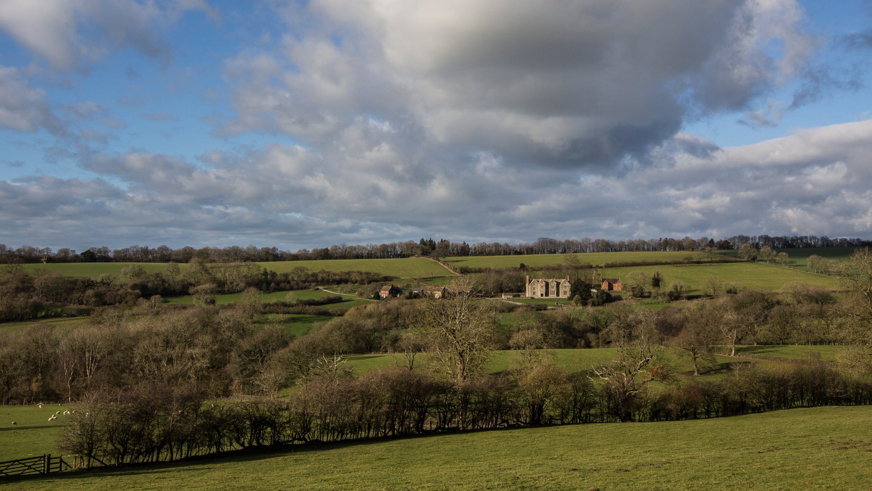 View over hedge-bordered fields to Wilderhope Manor at Wenlock Edge, Shropshire
