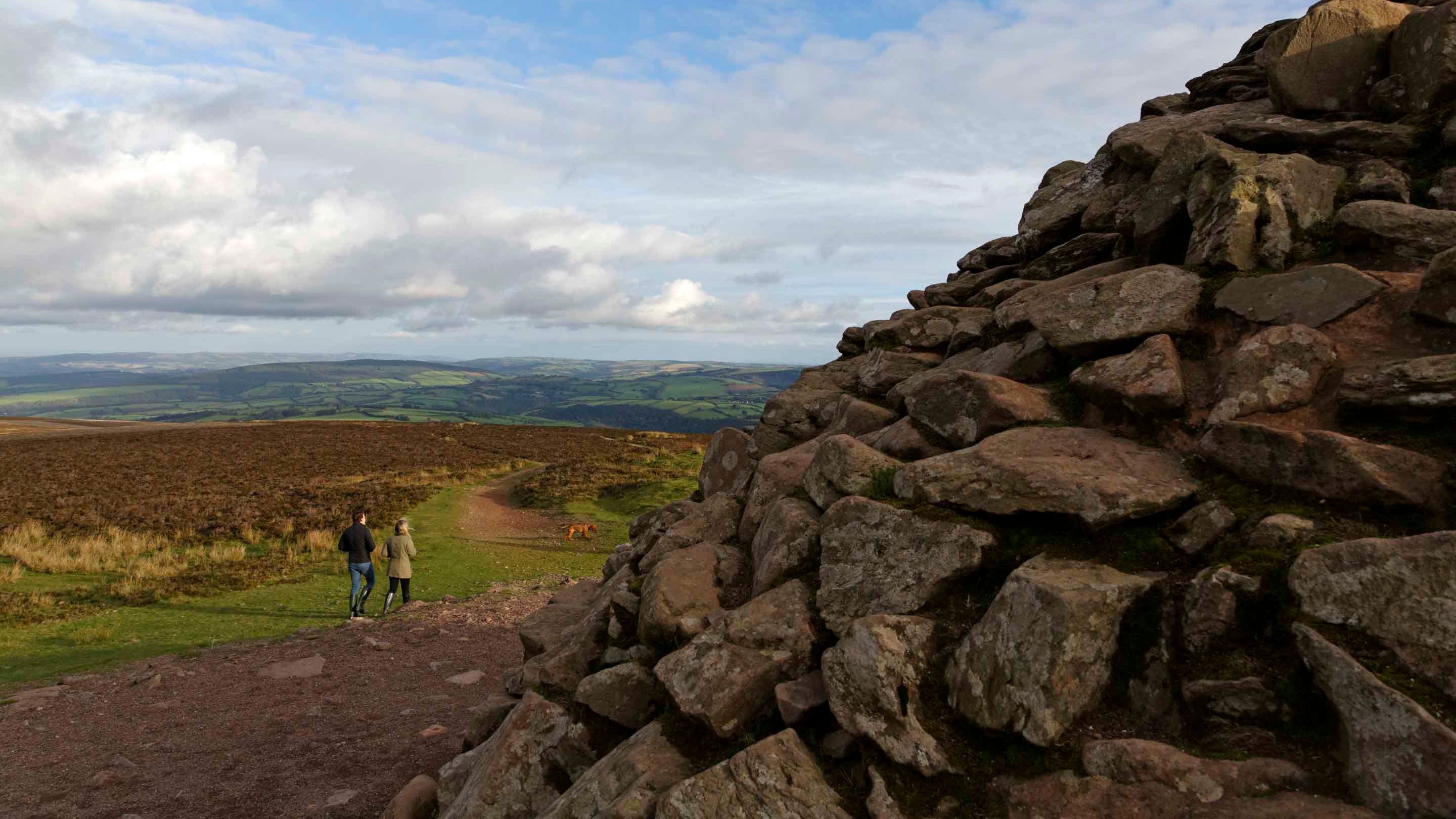 Two distant figures at Dunkery Beacon with views of Exmoor National Park in the background