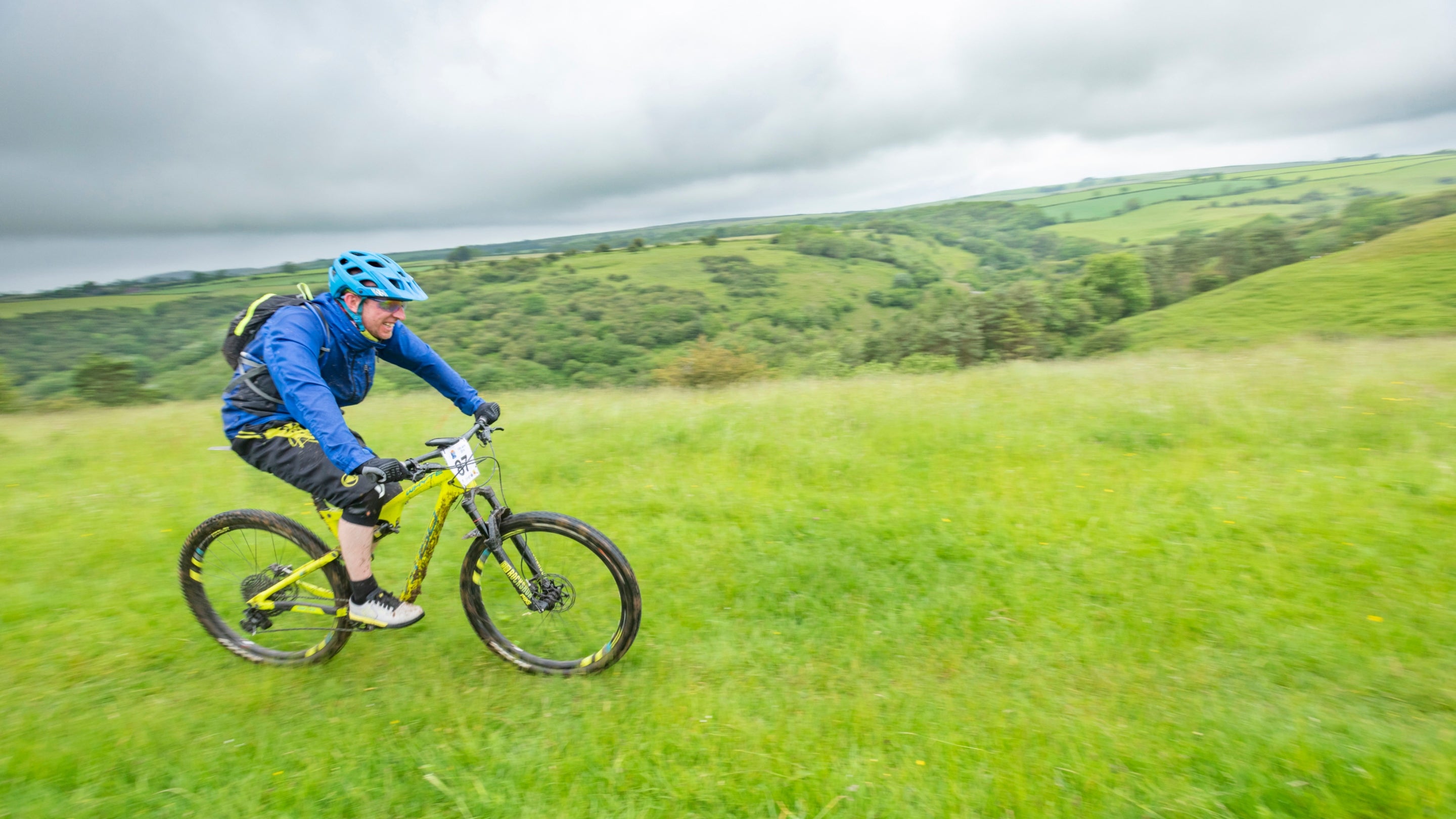 A cyclist riding across a grassy landscape