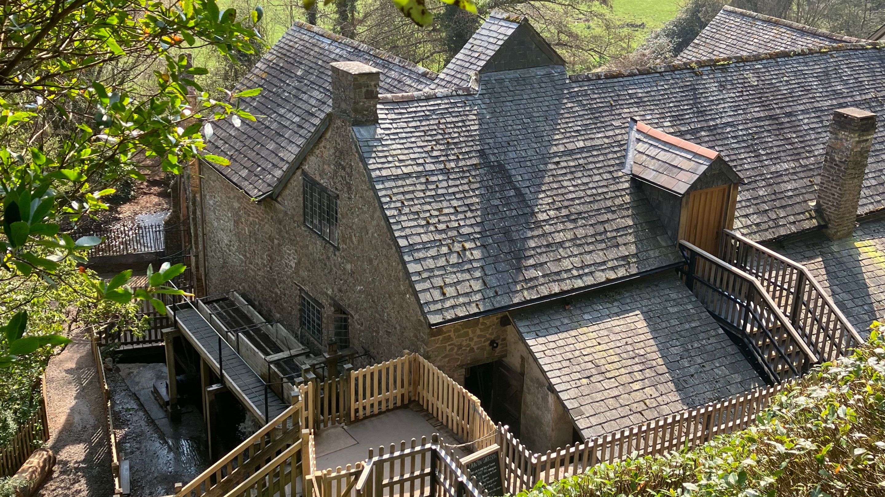 A view of Dunster Working Watermill and new bin floor dormer door from the Circular Path, Dunster Castle, Somerset