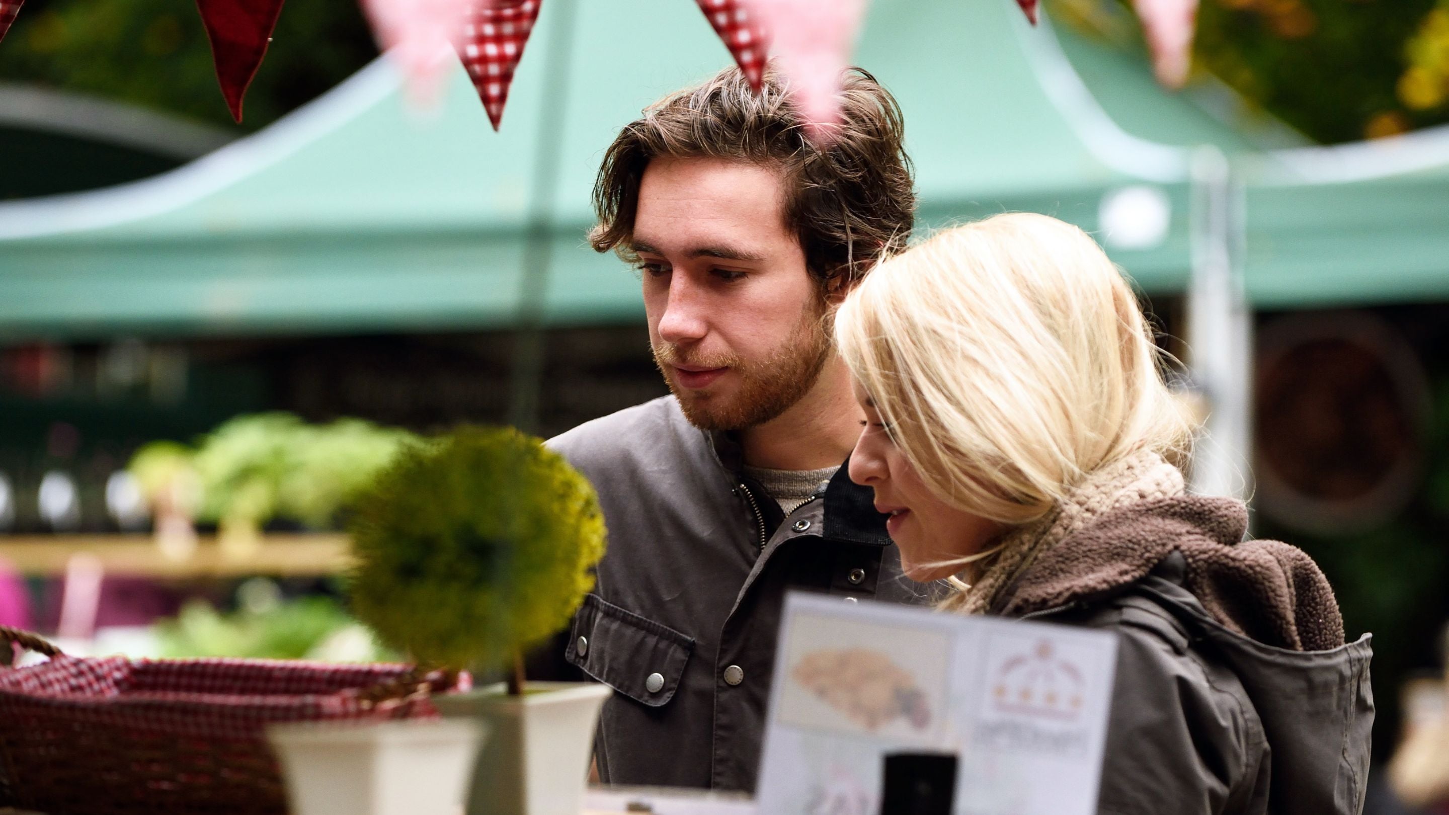 Two people looking at items on a market stall