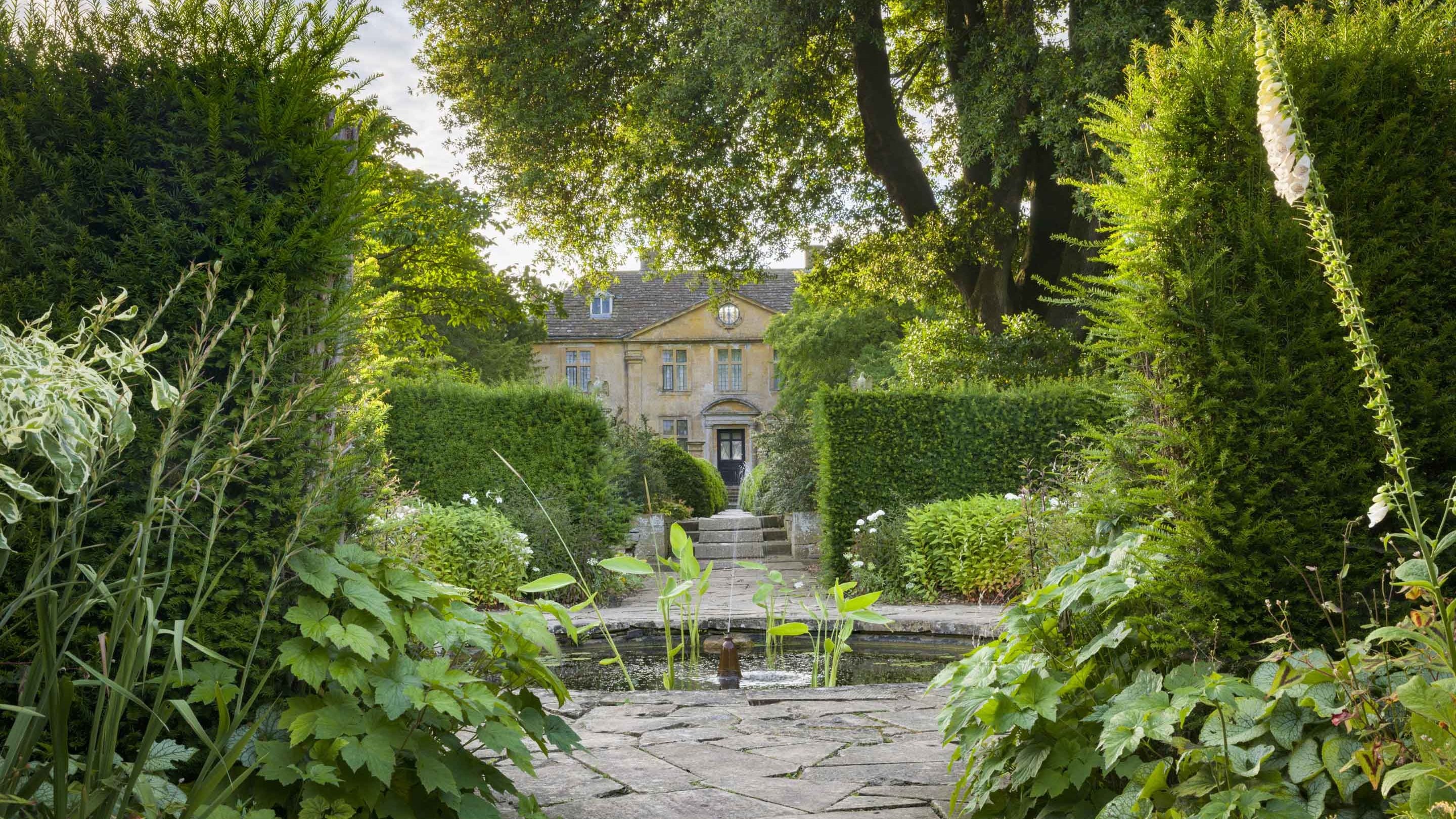 The front of the house at Tintinhull just visible through trees