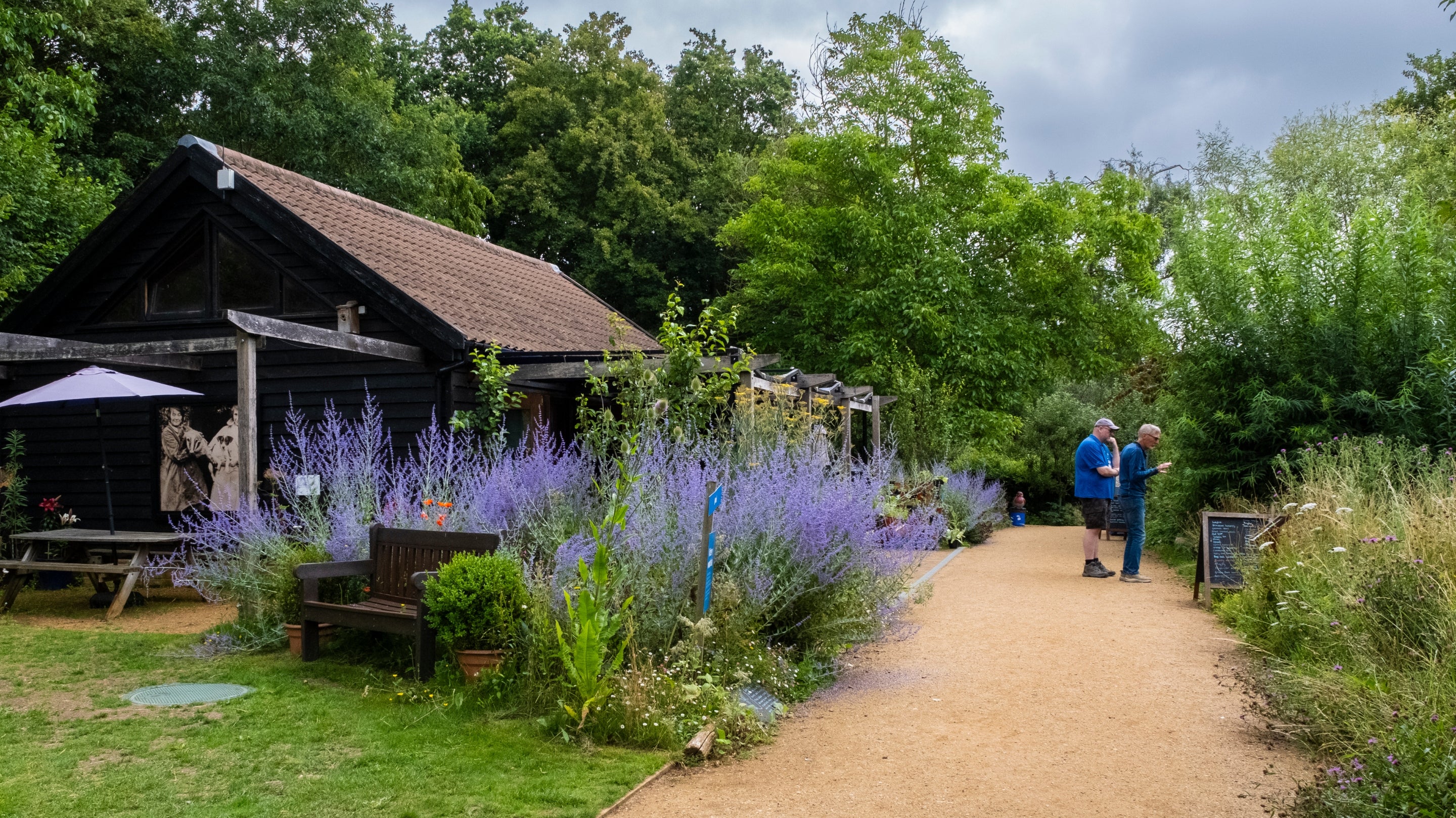 Two men standing on a path in the wildlife garden at Flatford
