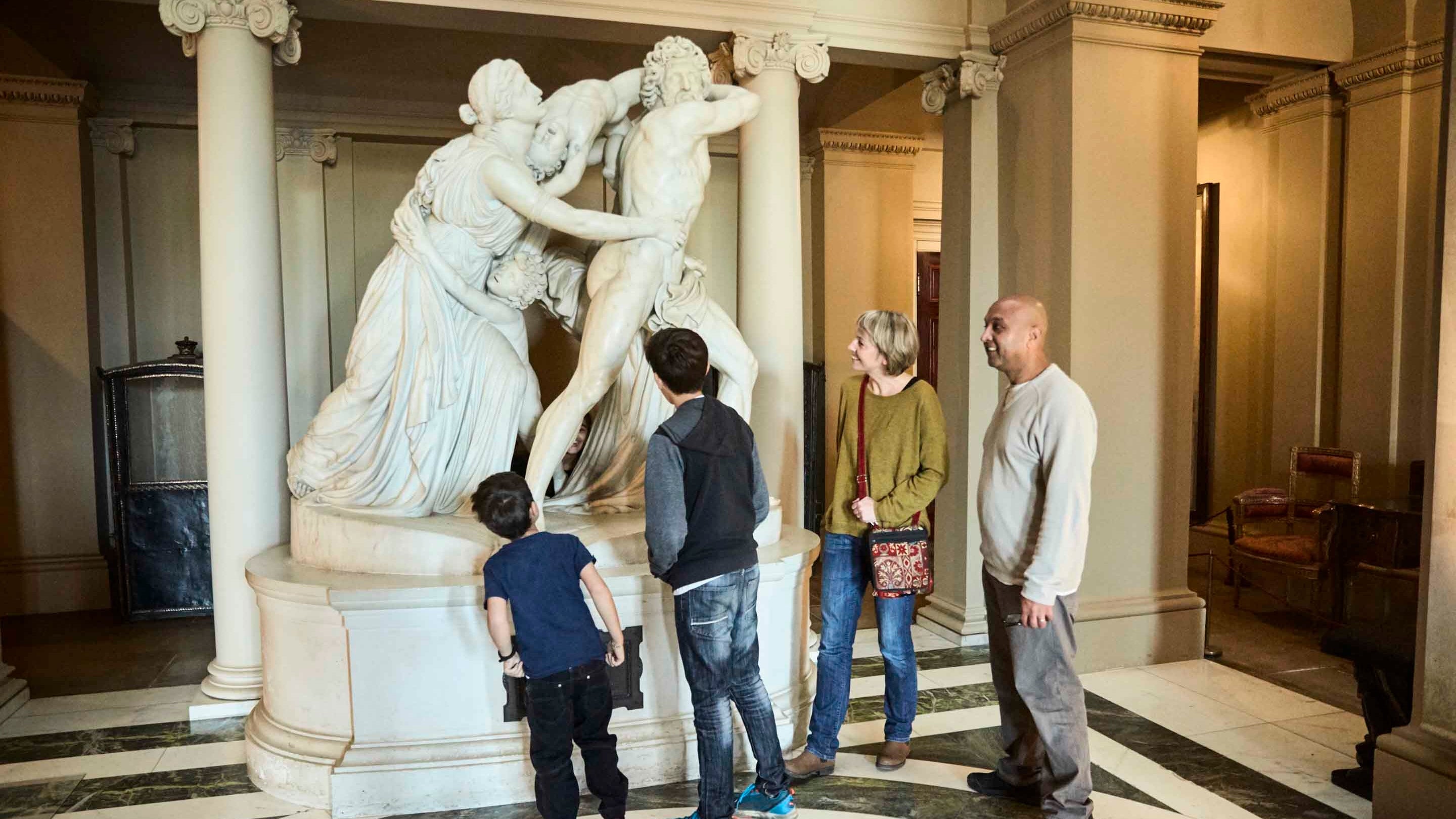 Visitors looking at a life-sized marble sculpture