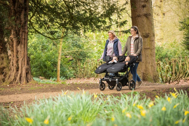 Two woman walking with pushchair in the Albana walk at Ickworth in spring