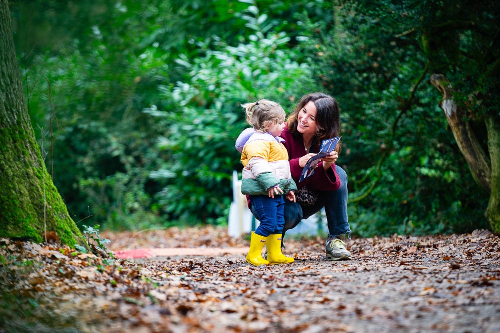 A young woman and a small child smile as they enjoy time together on the Albana walk