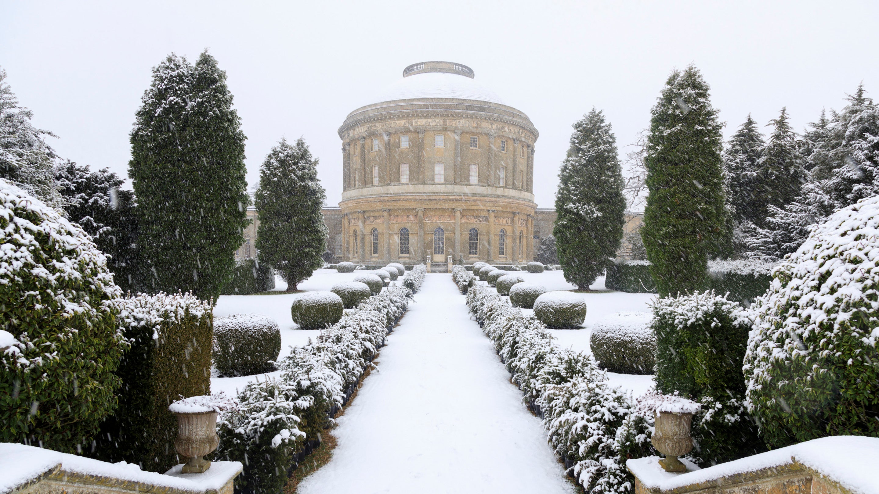 A photo of Ickworth rotunda and italianate garden in the snow. it is also snowing in the photo