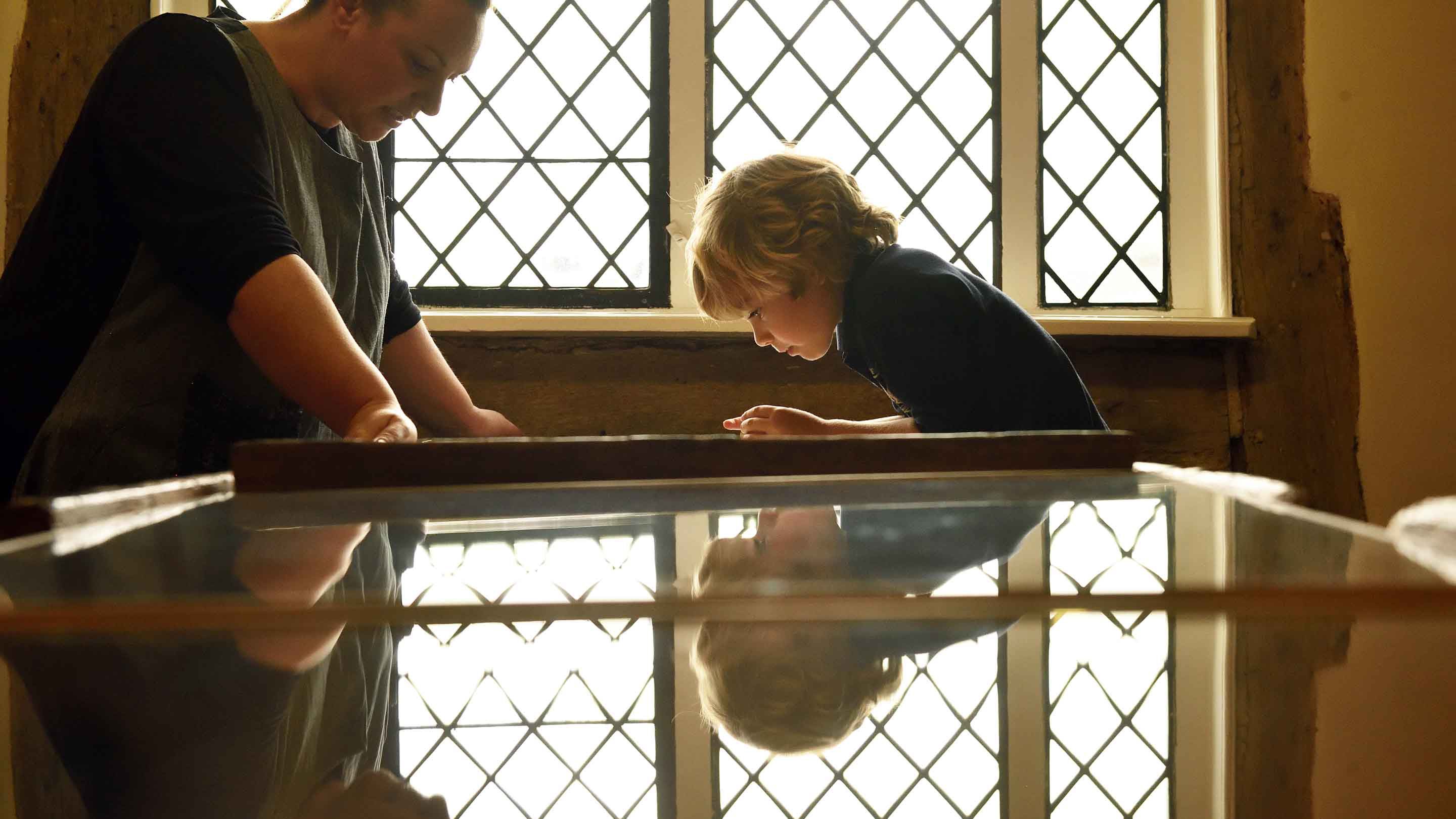 Woman and child studying an exhibition at Lavenham Guildhall, Suffolk