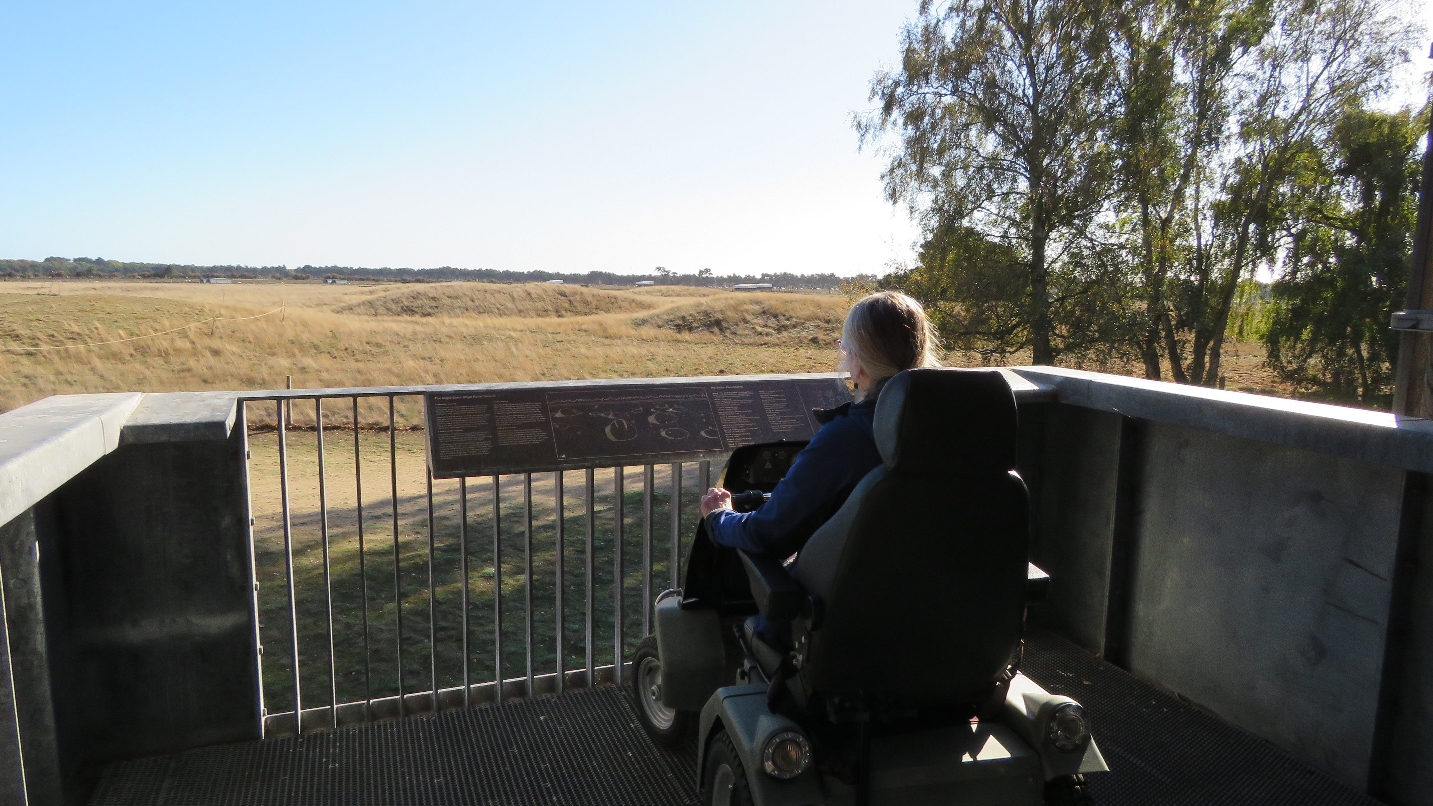 A visitor sitting in a powered electric vehicle on the first level of the viewing tower at Sutton Hoo