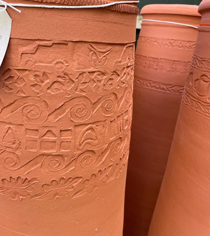 Close up of patterns pressed into the top of a red chimney pot