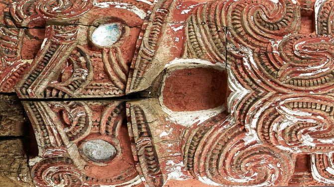 A Māori whakairo (carving) of a face painted red from the wharenui (meeting house) Hinemihi