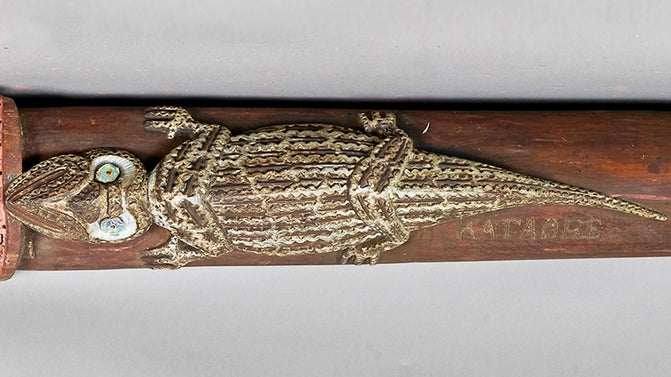A Maori whakairo (carving) of a lizard alongside the word Kataore from the wharenui (meeting house) Hinemihi