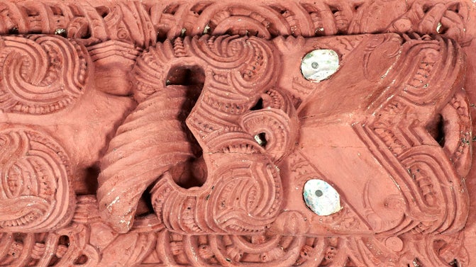 A Maori whakairo (carving) of a face painted red from the wharenui (meeting house) Hinemihi