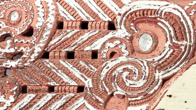 A Maori whakairo (carving) painted in red and white from the wharenui (meeting house) Hinemihi