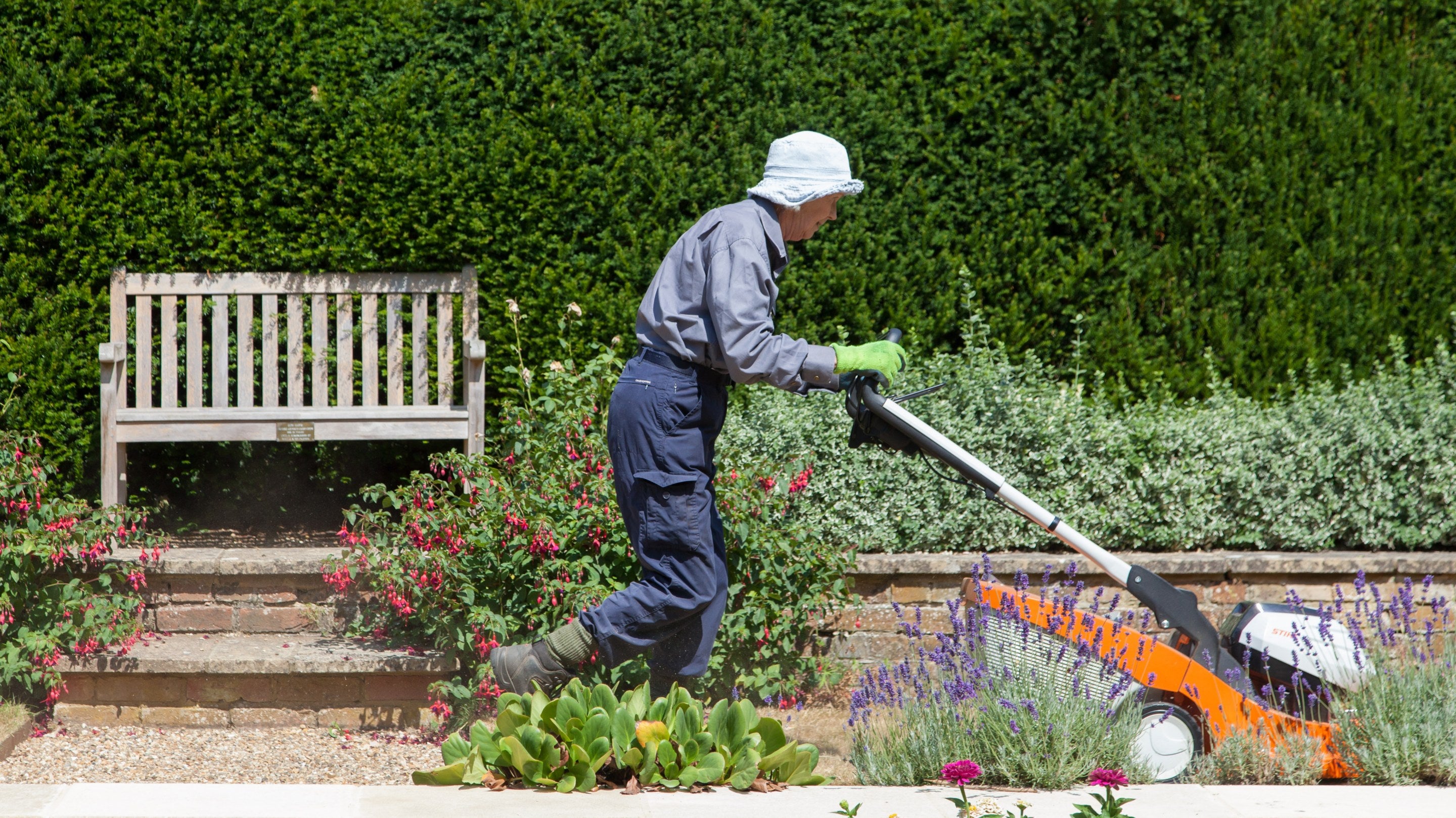 A gardener mows the lawn at Clandon Park, Surrey