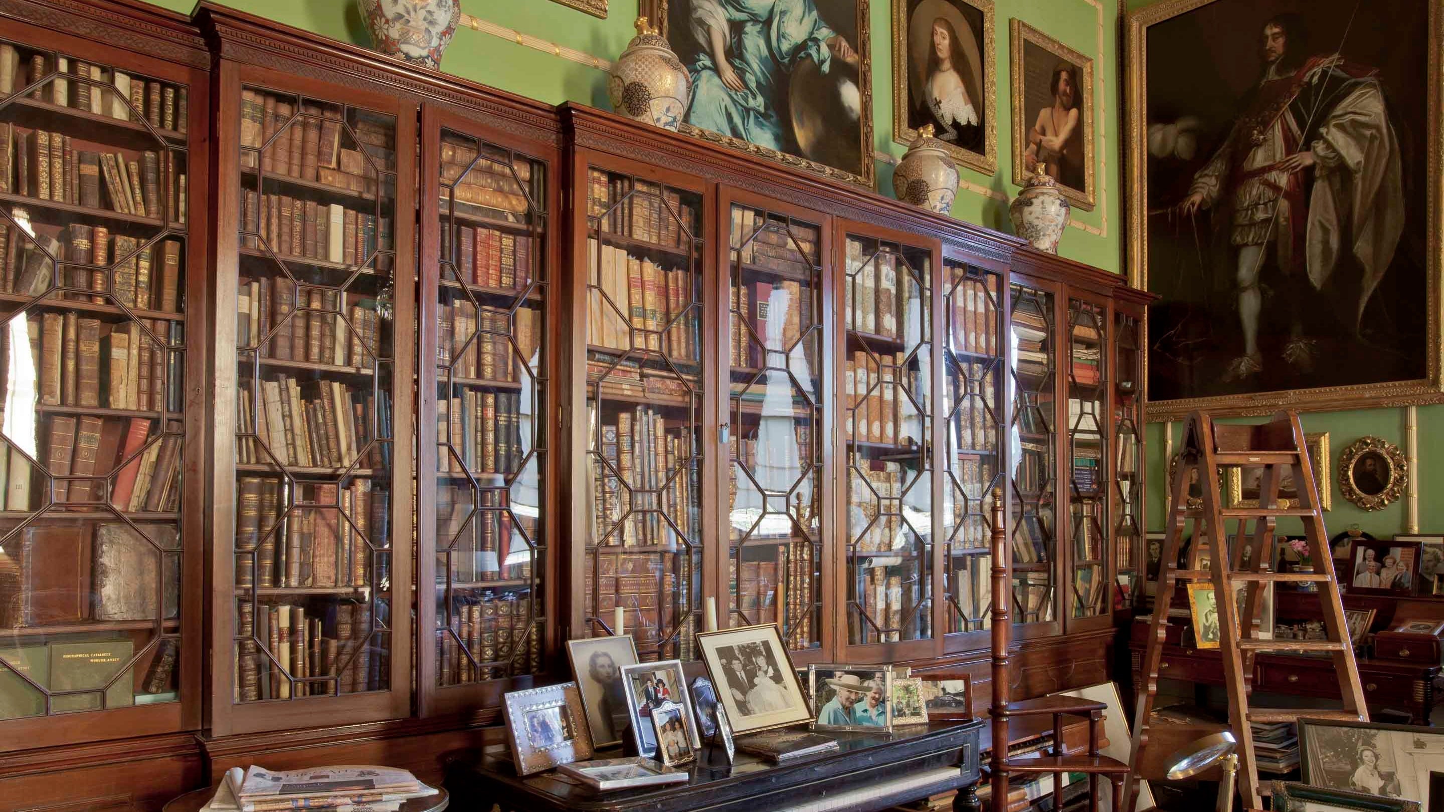 Wooden glass-fronted bookcases full of books in the Library at Hatchlands Park, Surrey