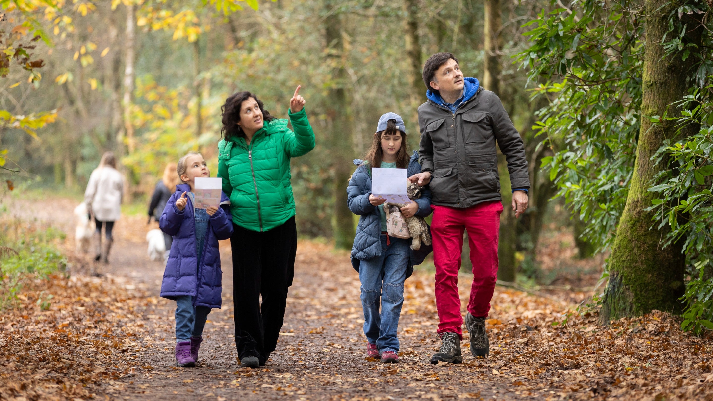 A man and woman and two children walking along the path at Hindhead Commons looking at a map