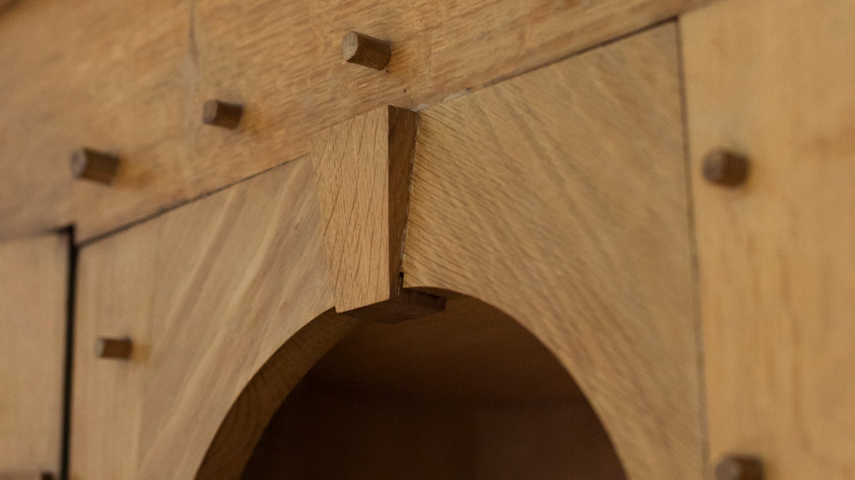 carved arched wooden detail peg studs on a bedroom shelving unit