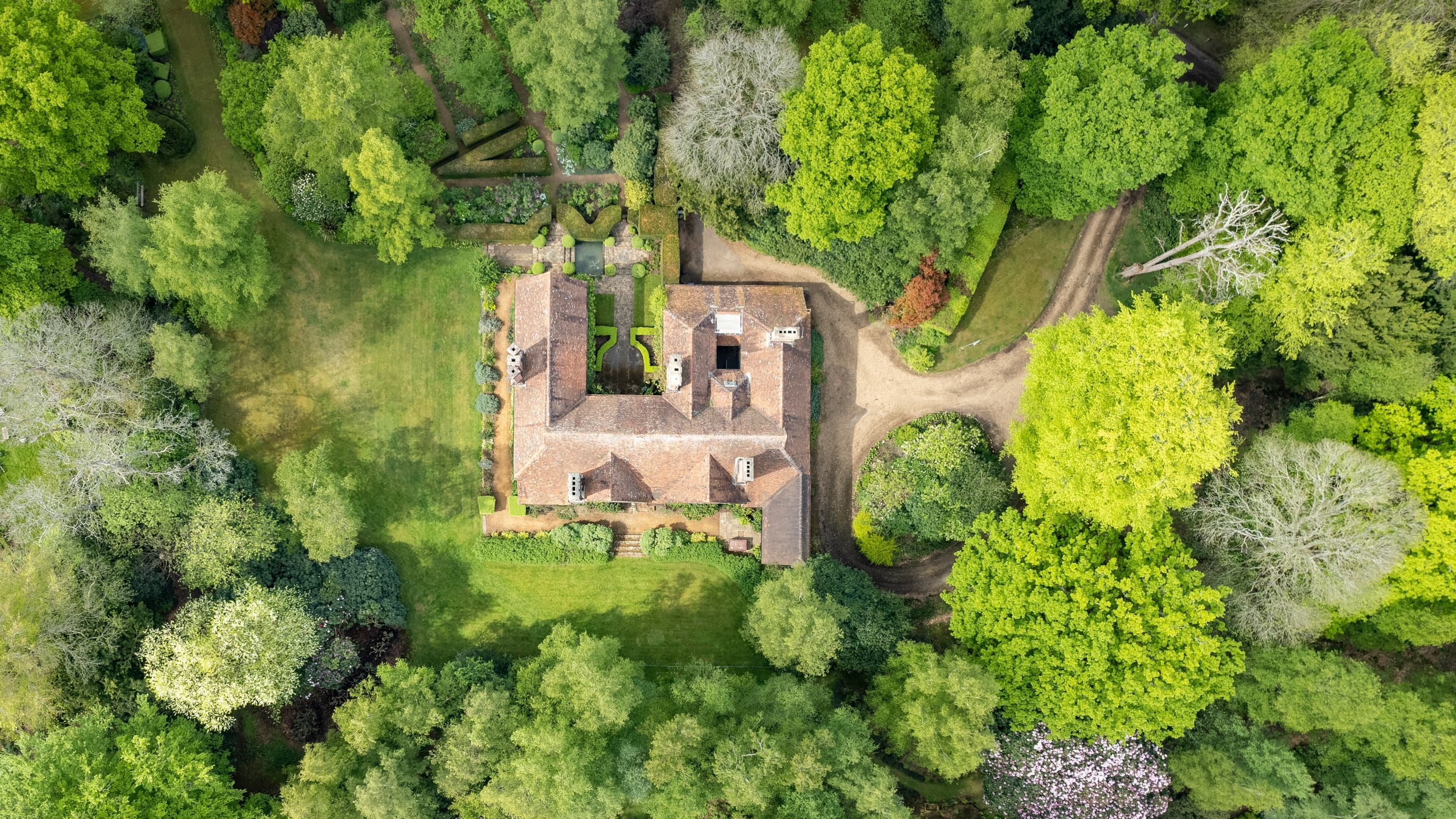 An aerial view of a house in a woodland glade at Munstead Wood, Surrey