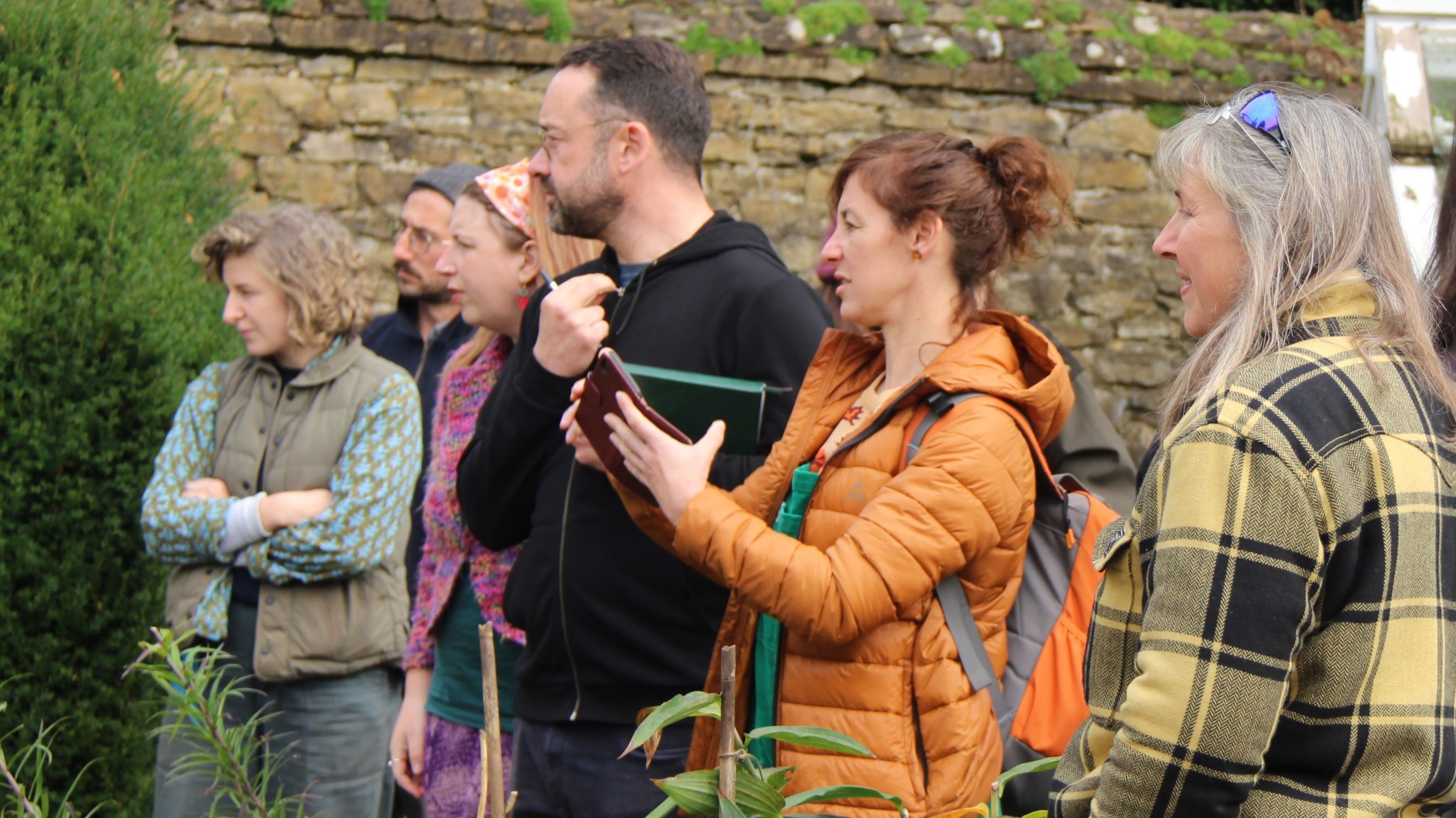 Tour group listening to guide in garden.