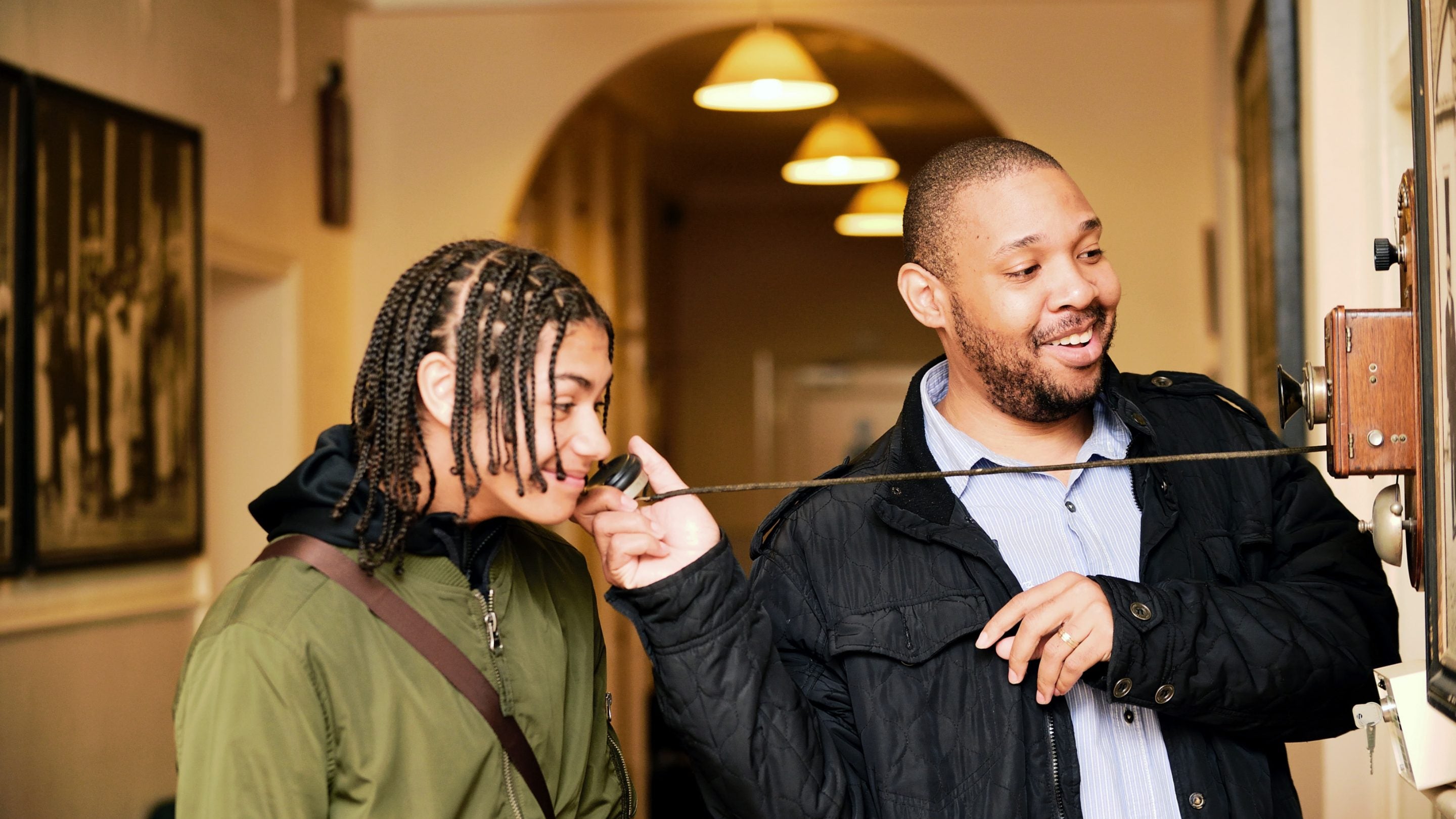 Two people using a vintage telephone