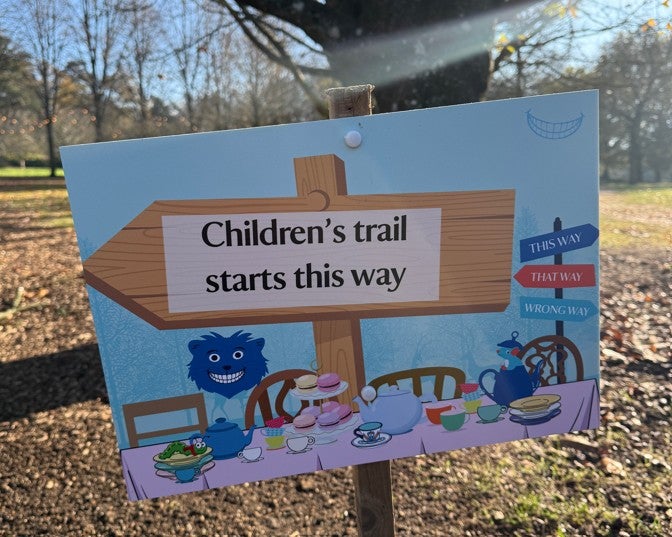 Alice's Christmas in Wonderland at Polesden Lacey 2025: a blue wooden sign reading 'Children's trail starts this way'