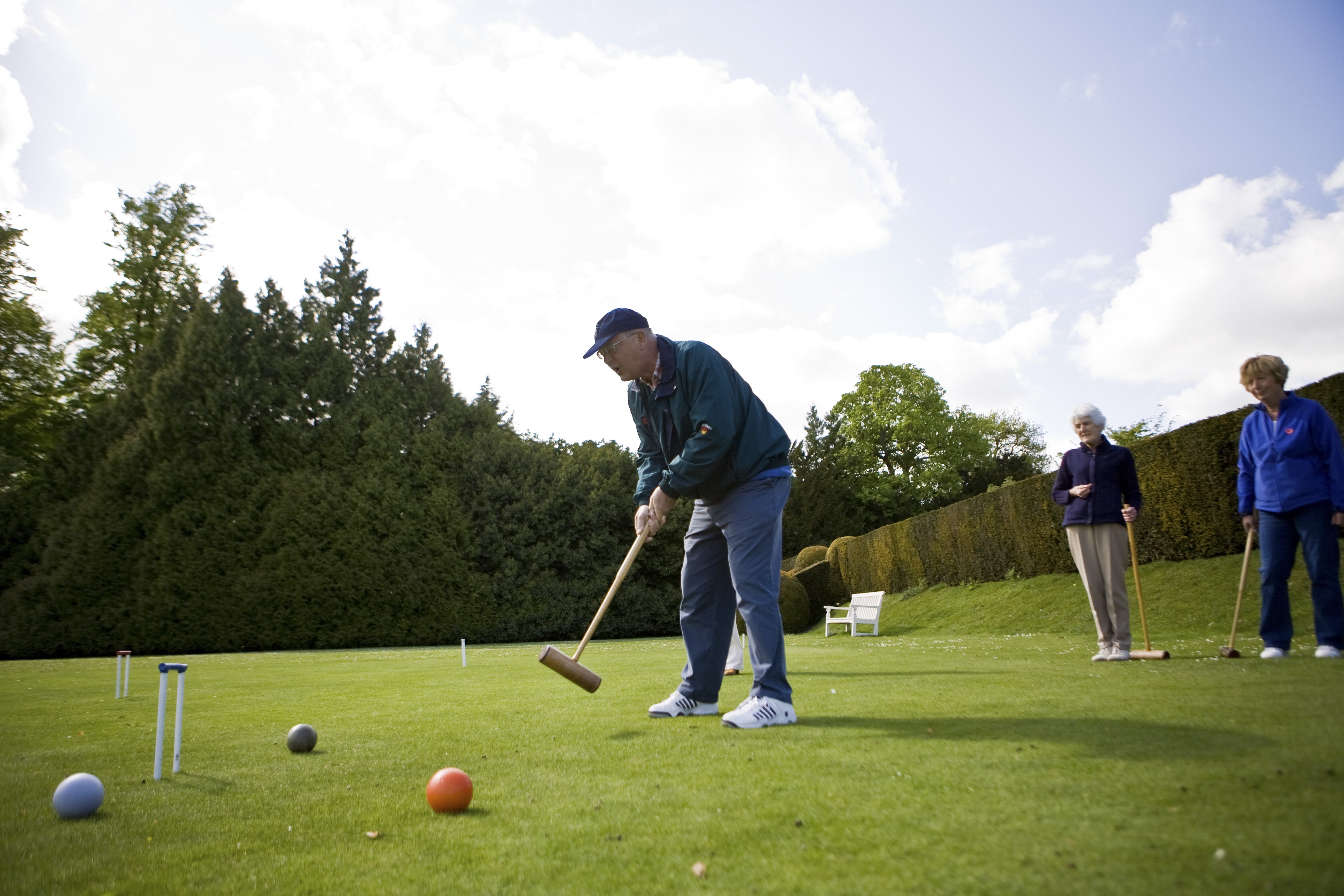 A man and two ladies playing croquet at Polesden Lacey