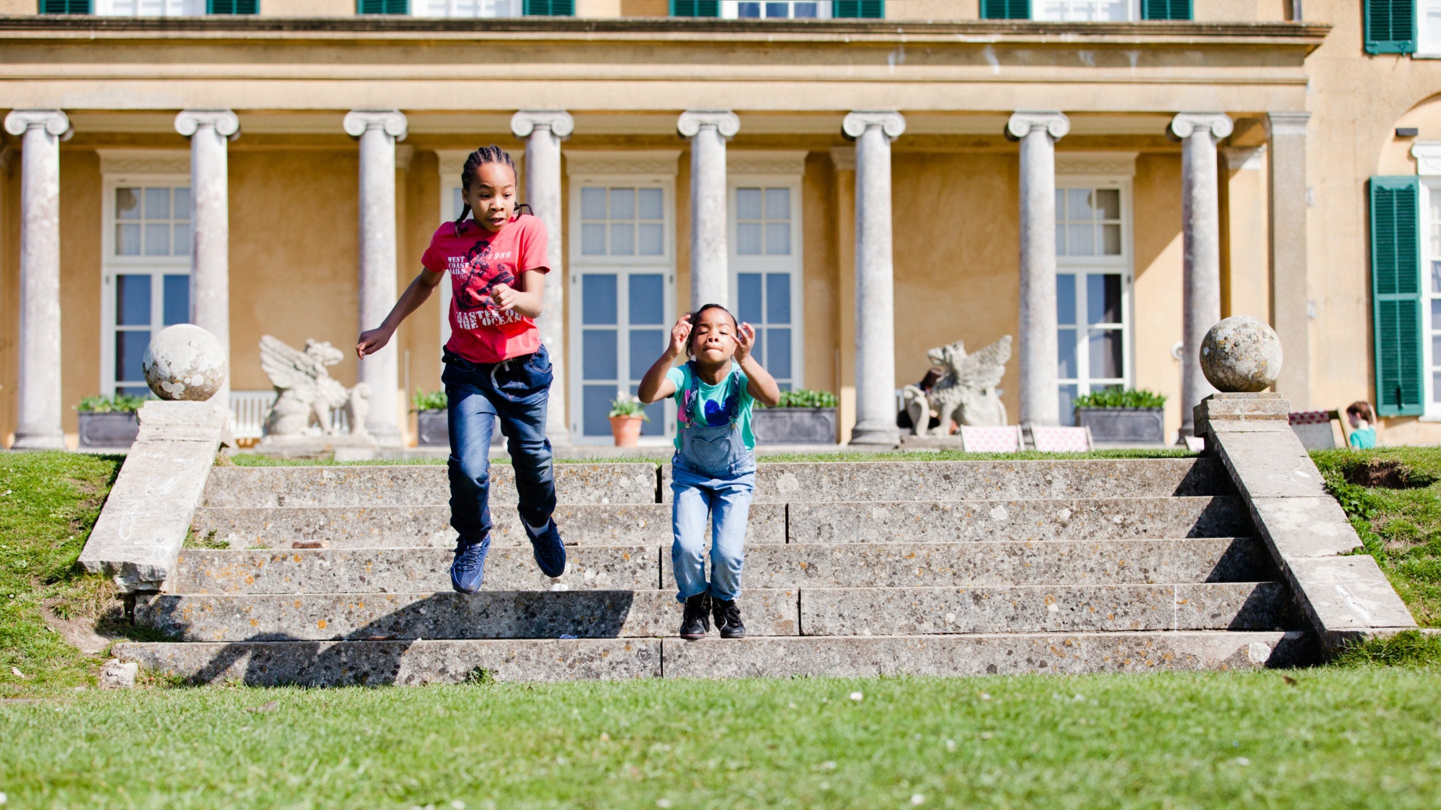 Two children jumping down stone steps