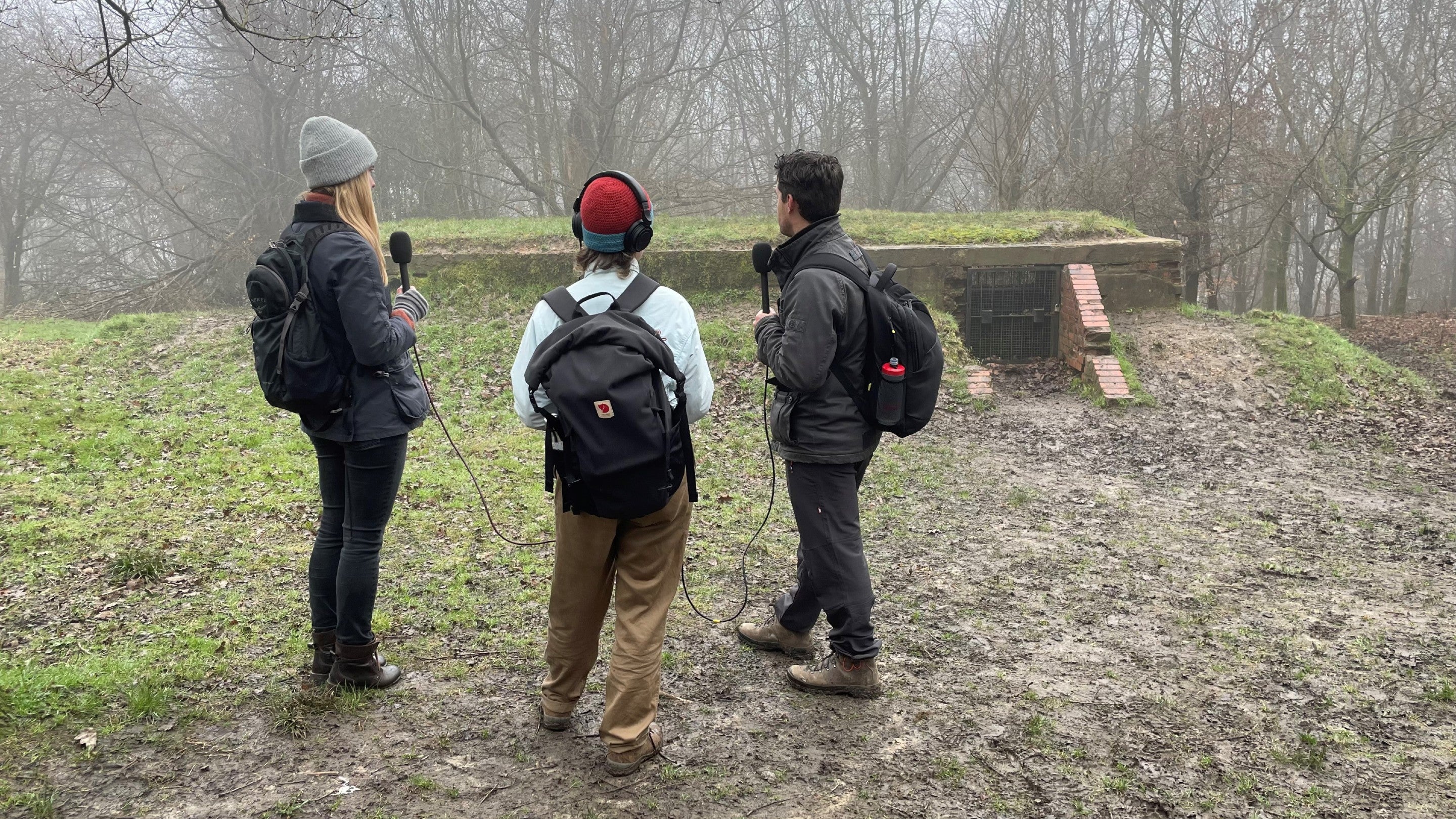 Three people taking part in a podcast recording on a misty day at  Reigate Fort