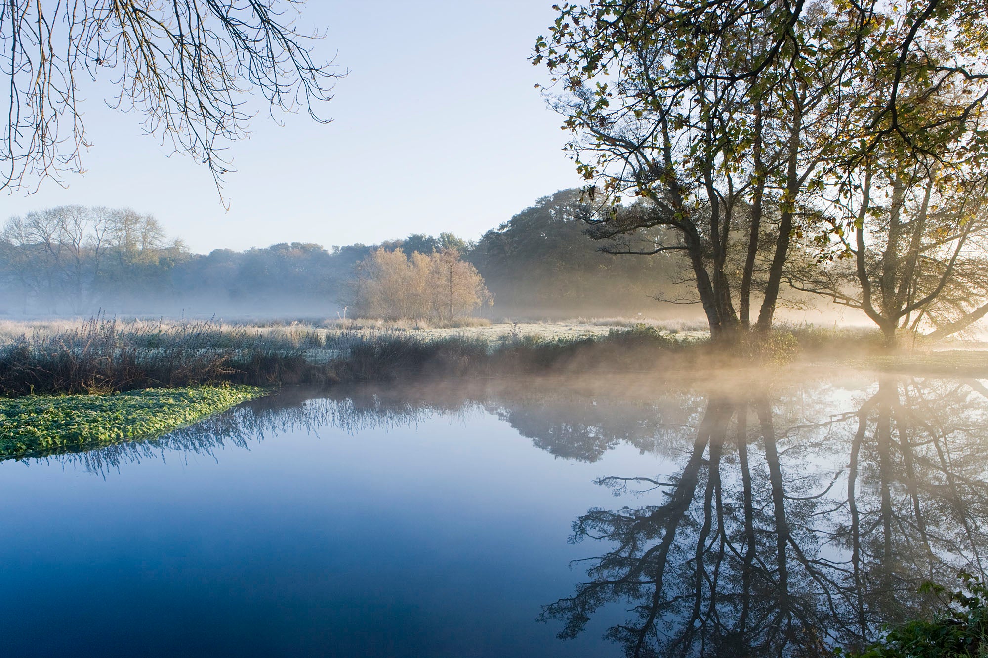 Blue river with frosty fields