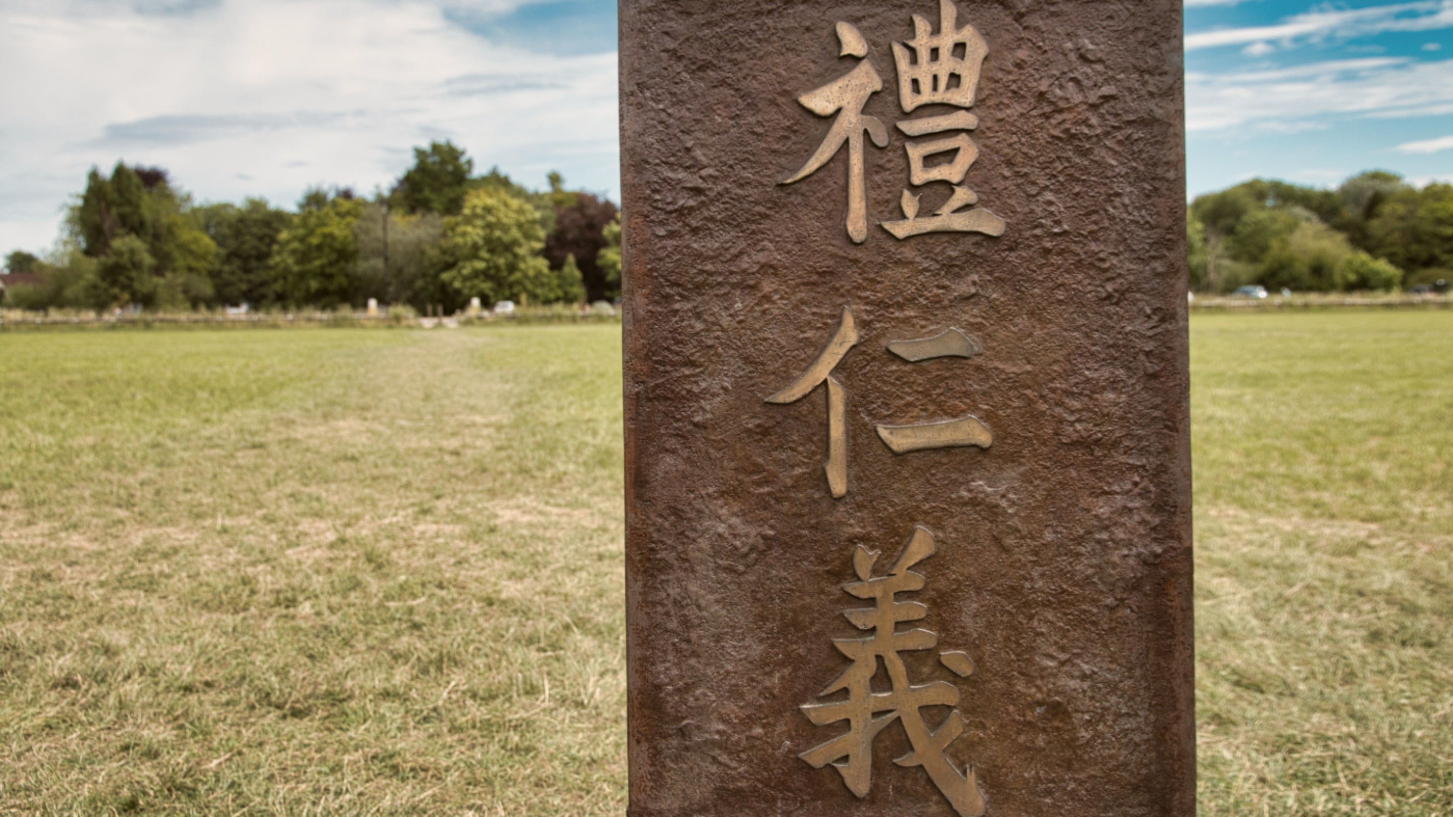 Close-up of chair 10 of The Jurors by Hew Locke, an artwork on display at Runnymede, Surrey, showing Chinese script that describes the Confucian principles of Ren (humaneness), Li (ritual) and Yi (justice)