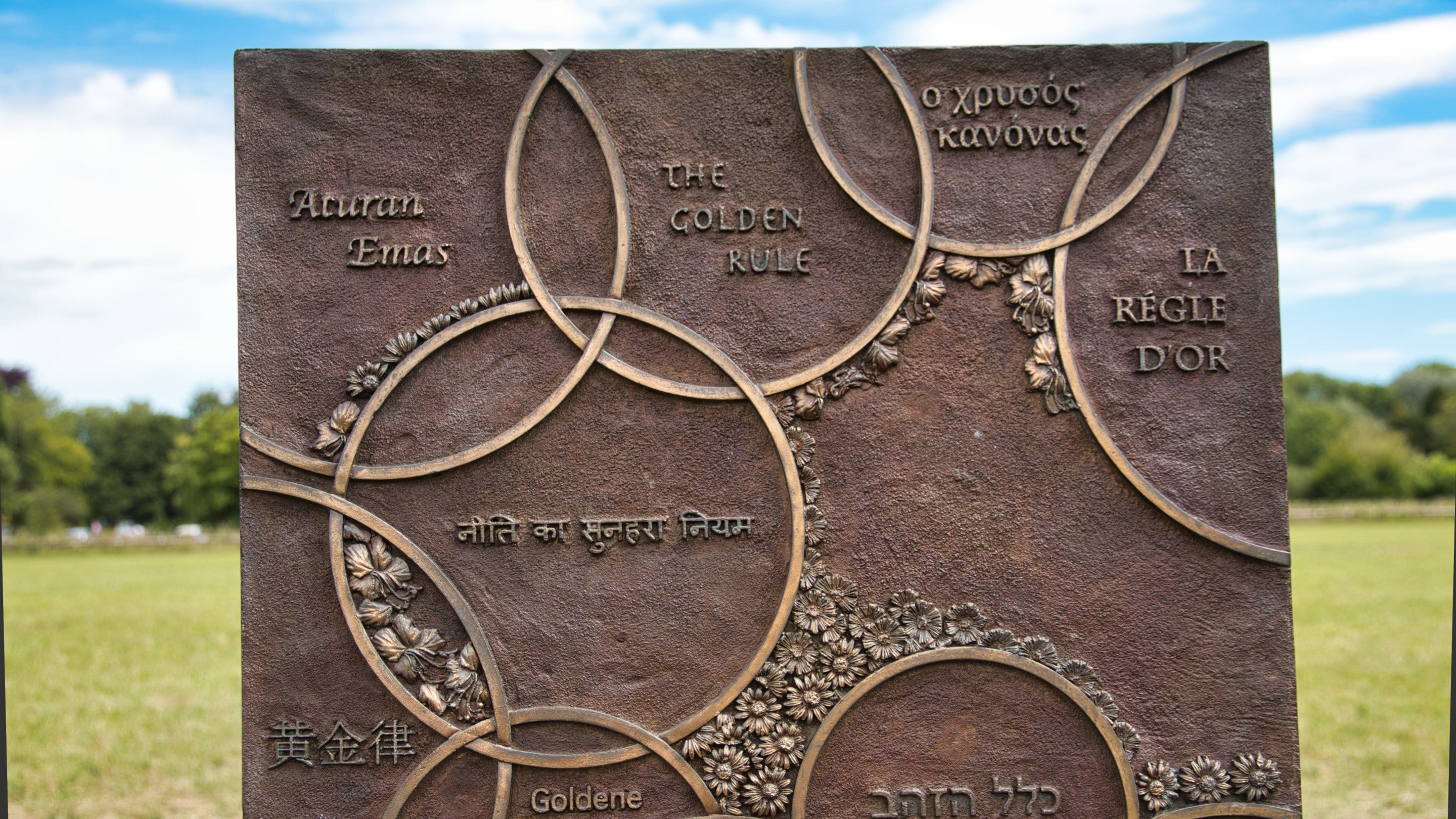 Close-up of chair 9 of The Jurors by Hew Locke, an artwork on display at Runnymede, Surrey, 'The Golden Rule' that states you should treat others as you would wish to be treated yourself, expressed in 14 languages